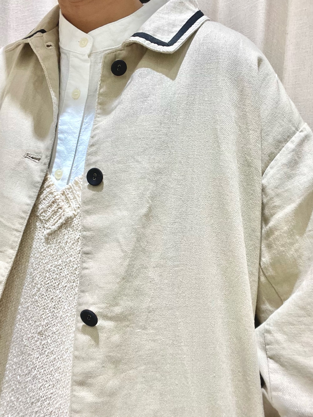 ホワイト系のチュニック、ホワイト系のベスト、ベージュ系のその他アウターを着用したレディースの春コーディネートの5枚目の写真