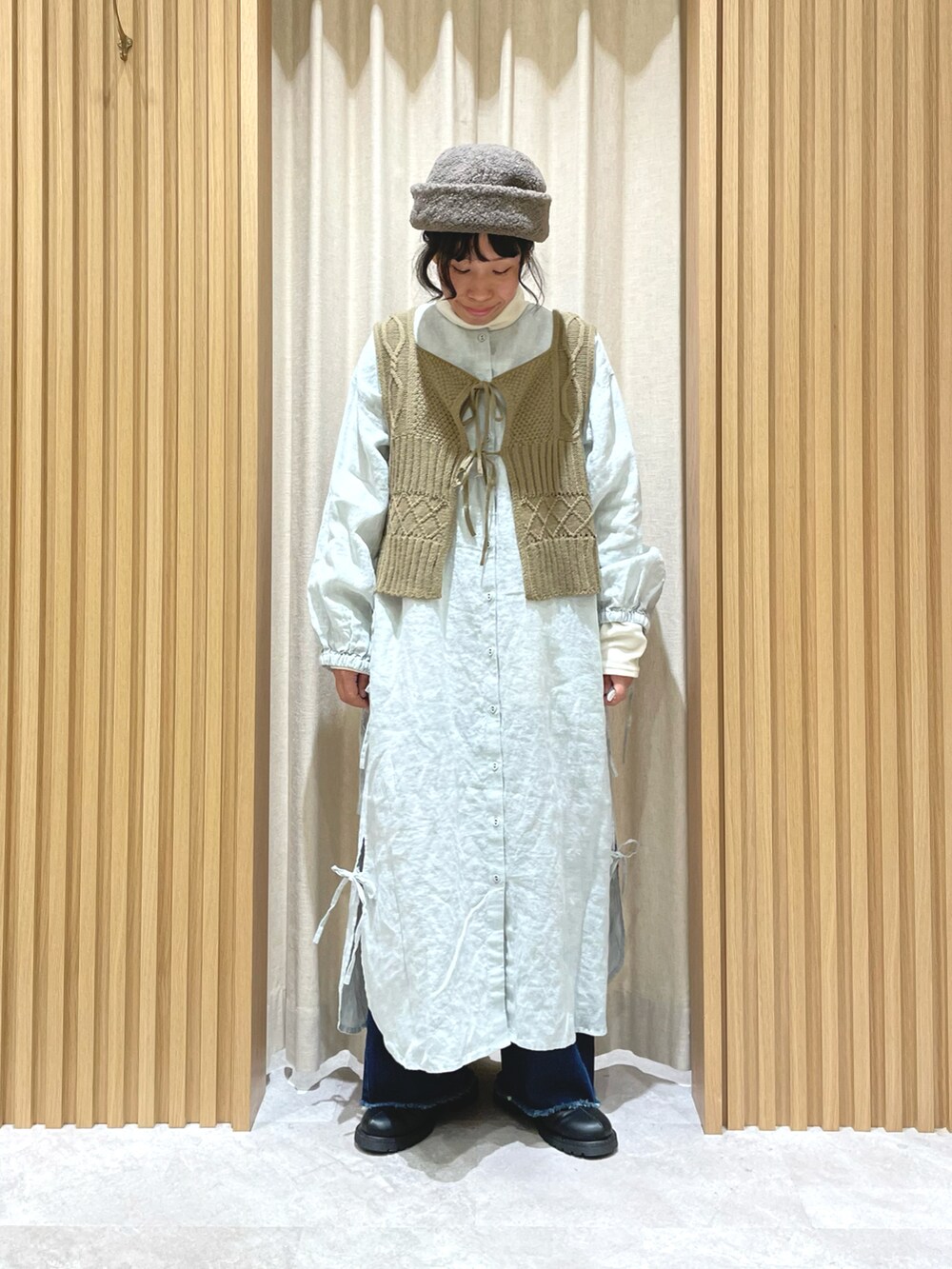 ホワイト系のTシャツ/カットソー、ベージュ系のベスト、グリーン系のワンピースを着用したレディースの冬コーディネートの3枚目の写真