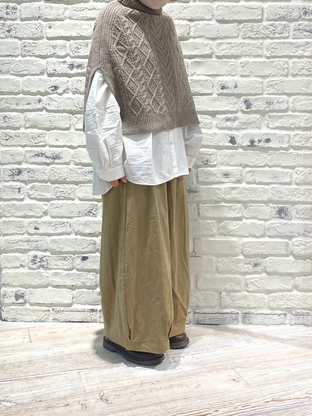 ホワイト系のシャツ/ブラウス、ブラウン系のブーツ、ベージュ系のパンツを着用したレディースの秋コーディネートの2枚目の写真