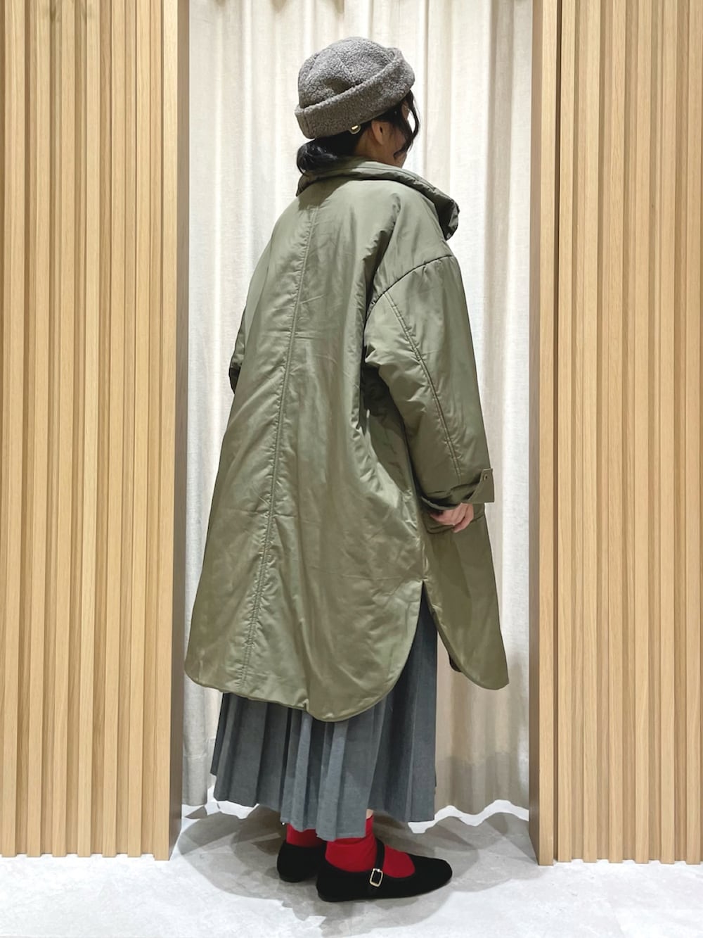 ブルー系のニット/セーター、グレー系のスカート、グリーン系のその他アウターを着用したレディースの冬コーディネートの3枚目の写真