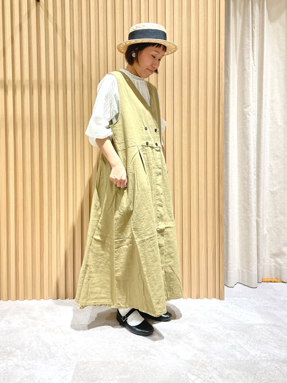 ホワイト系のシャツ/ブラウス、イエロー系のワンピース、ブラック系のバレエシューズを着用したレディースの春コーディネートの2枚目の写真