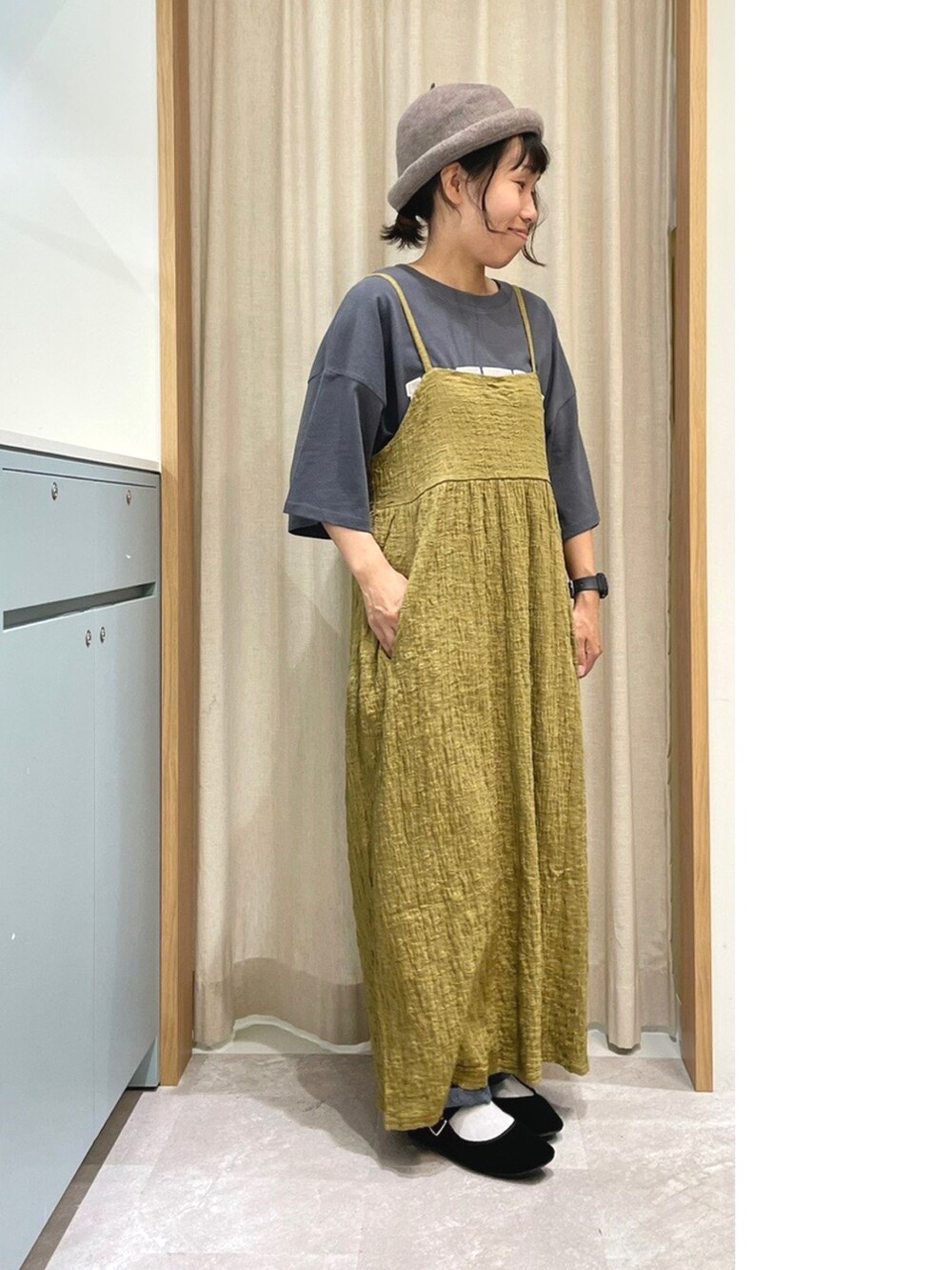 グレー系のTシャツ/カットソー、ベージュ系のワンピース、ブルー系のデニムパンツを着用したレディースの夏コーディネートの2枚目の写真