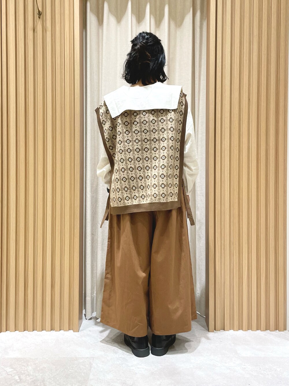 ホワイト系のシャツ/ブラウス、ベージュ系のブルゾン、ブラウン系のベストを着用したレディースの秋コーディネートの2枚目の写真