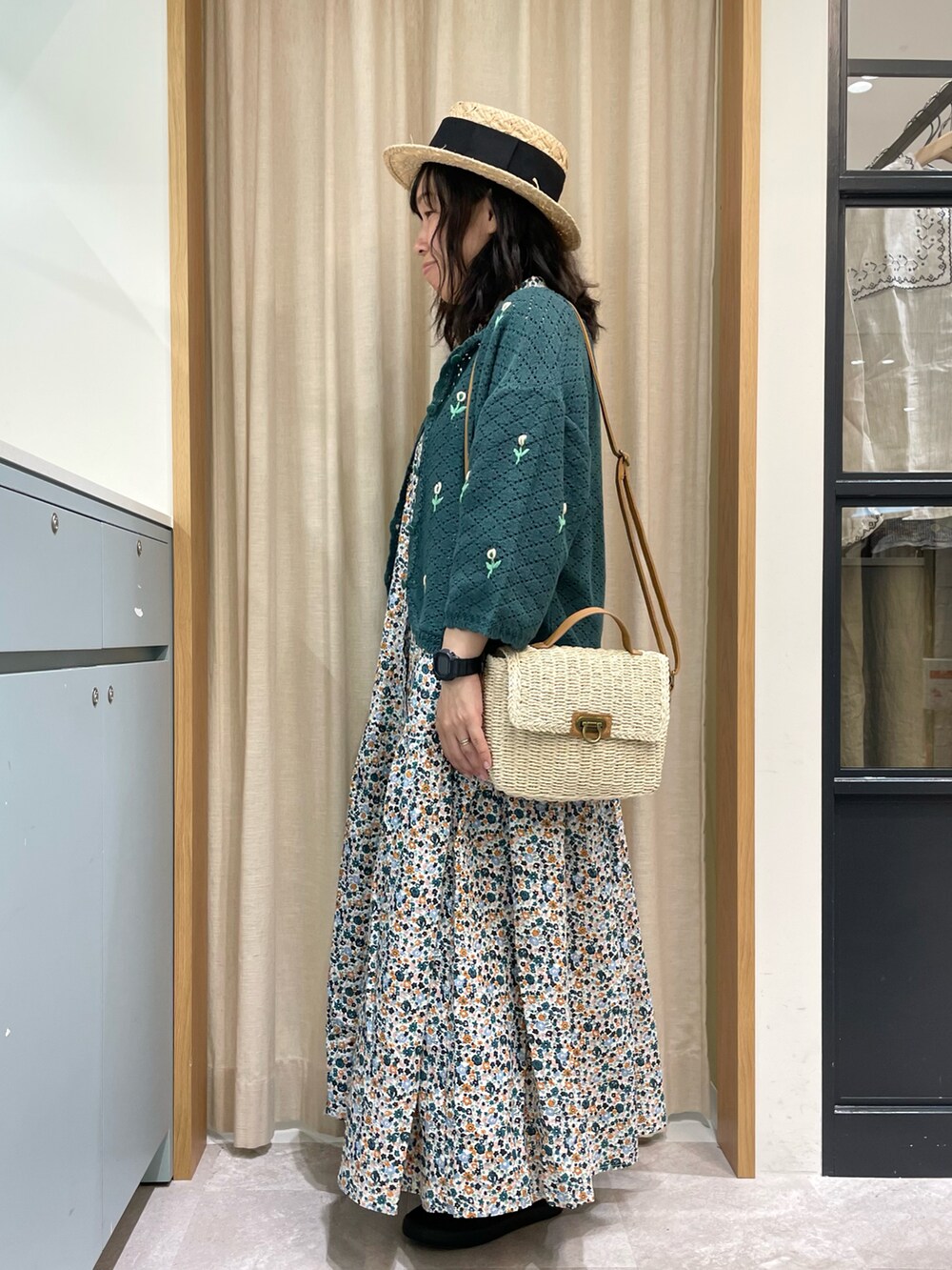 ホワイト系のワンピース、グリーン系のカーディガン/ボレロ、ホワイト系のハンドバッグを着用したレディースの夏コーディネートの2枚目の写真