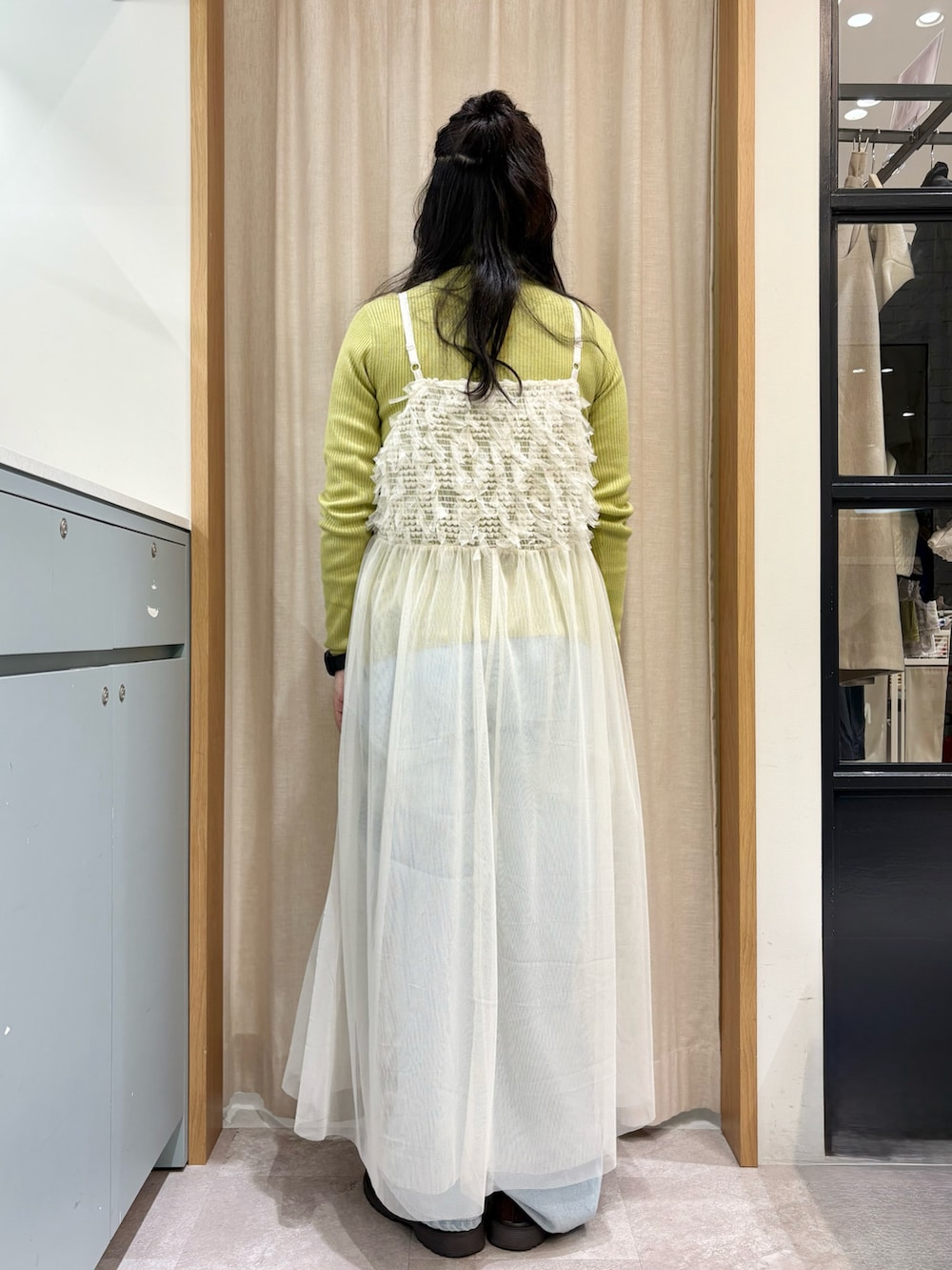 ホワイト系のワンピース、グリーン系のニット/セーター、ブルー系のその他パンツを着用したレディースの冬コーディネートの2枚目の写真
