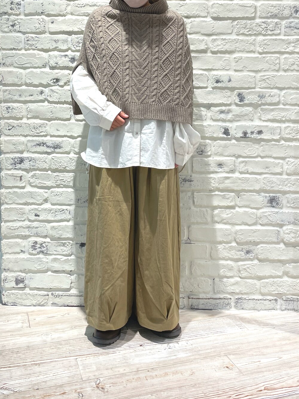 ホワイト系のシャツ/ブラウス、ブラウン系のブーツ、ベージュ系のパンツを着用したレディースの秋コーディネートの3枚目の写真