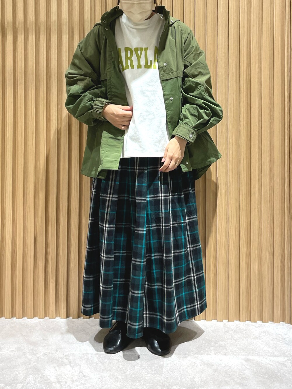 ブラック系のその他シューズ、グリーン系のブルゾン、ブルー系のスカートを着用したレディースの春コーディネートの2枚目の写真