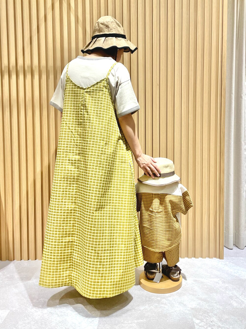 ベージュ系のTシャツ/カットソー、イエロー系のワンピース、ブラウン系のサンダルを着用したレディースの夏コーディネートの2枚目の写真