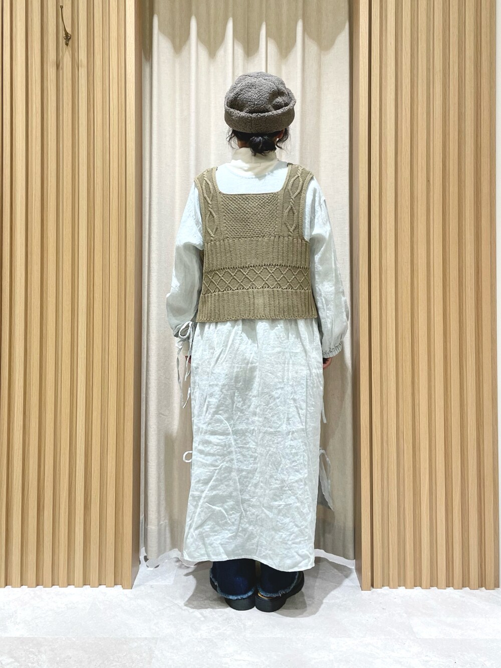 ホワイト系のTシャツ/カットソー、ベージュ系のベスト、グリーン系のワンピースを着用したレディースの冬コーディネートの2枚目の写真