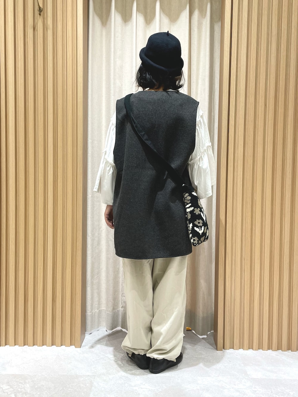 ブラウン系のベスト、ホワイト系のTシャツ/カットソー、ブラック系のハンドバッグを着用したレディースの秋コーディネートの2枚目の写真