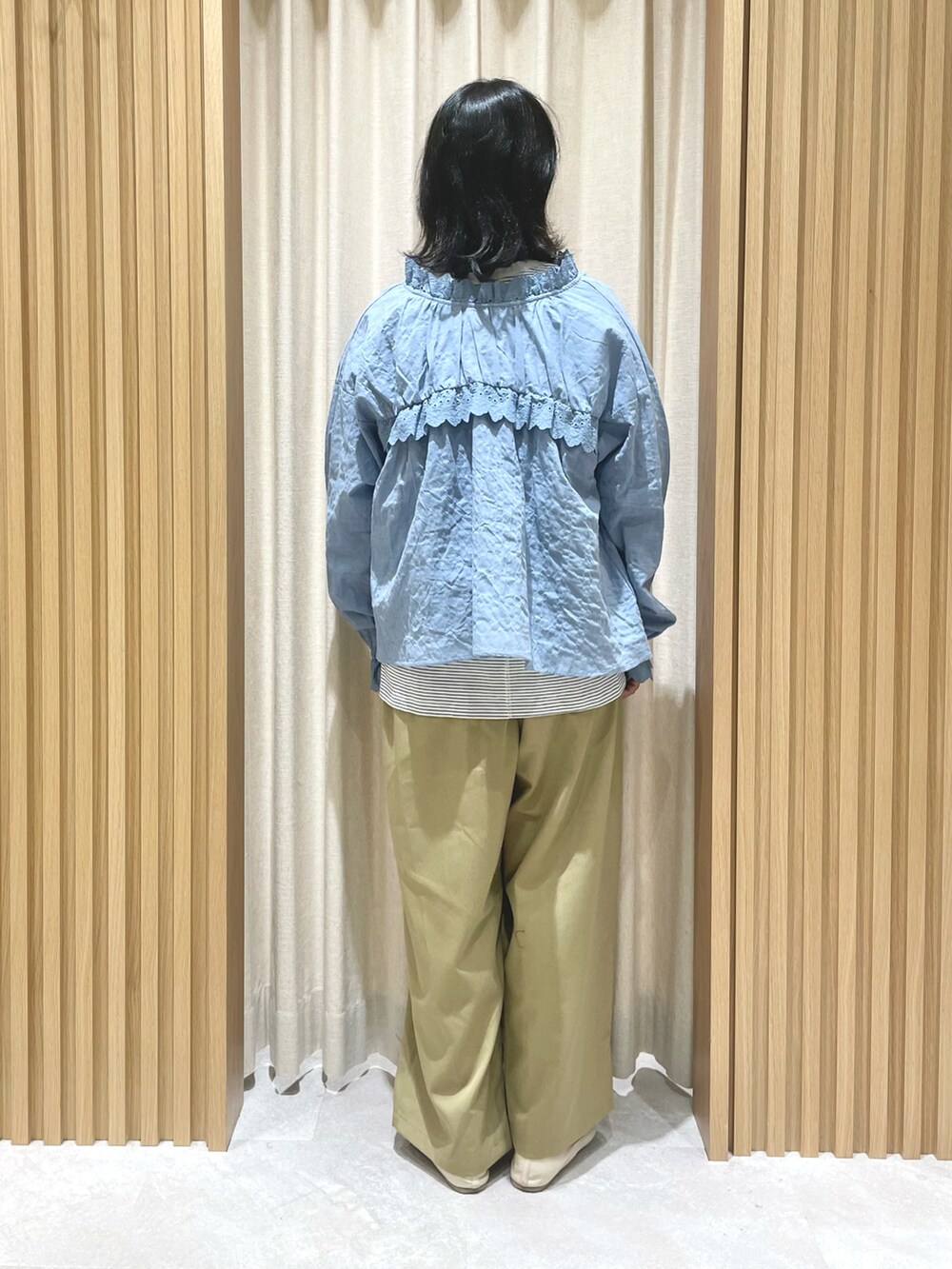 ブルー系のTシャツ/カットソー、ブルー系のシャツ/ブラウス、ベージュ系のスラックスを着用したレディースの冬コーディネートの4枚目の写真