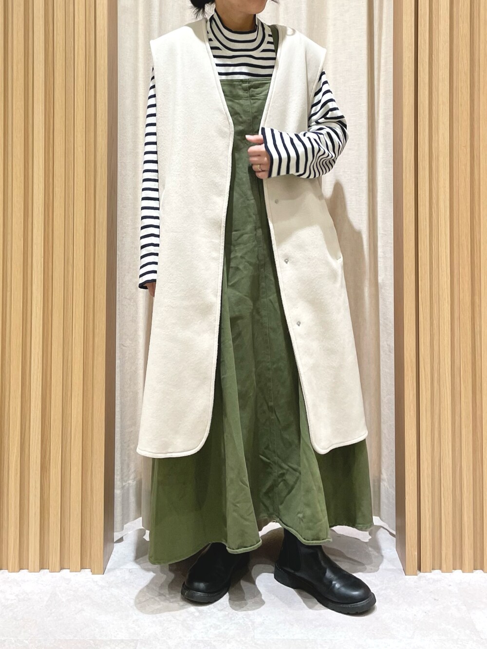 ブルー系のニット/セーター、グリーン系のワンピース、ホワイト系のベストを着用したレディースの冬コーディネートの5枚目の写真