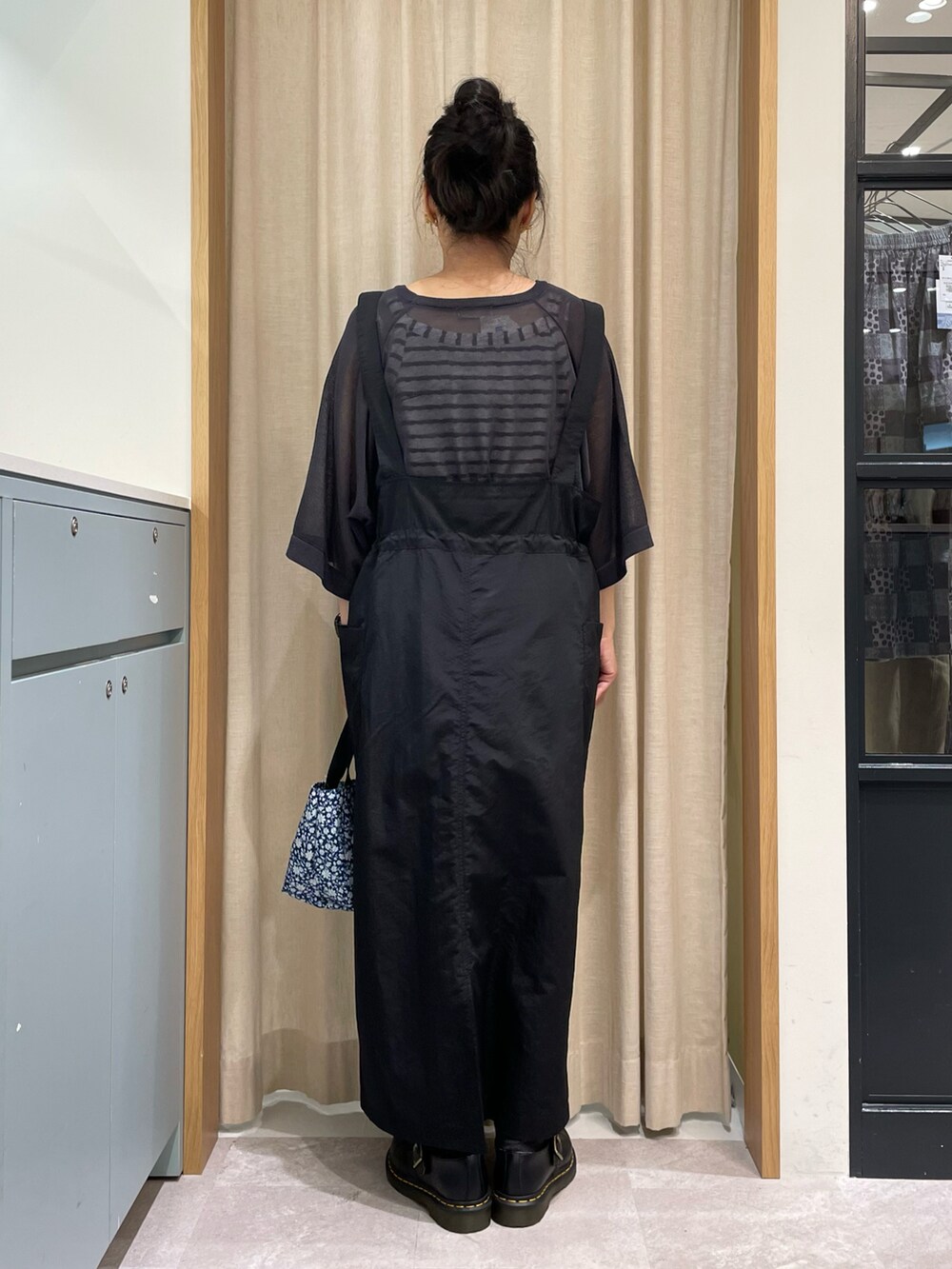 ホワイト系のTシャツ/カットソー、グレー系のニット/セーター、ブラック系のスカートを着用したレディースの春コーディネートの2枚目の写真