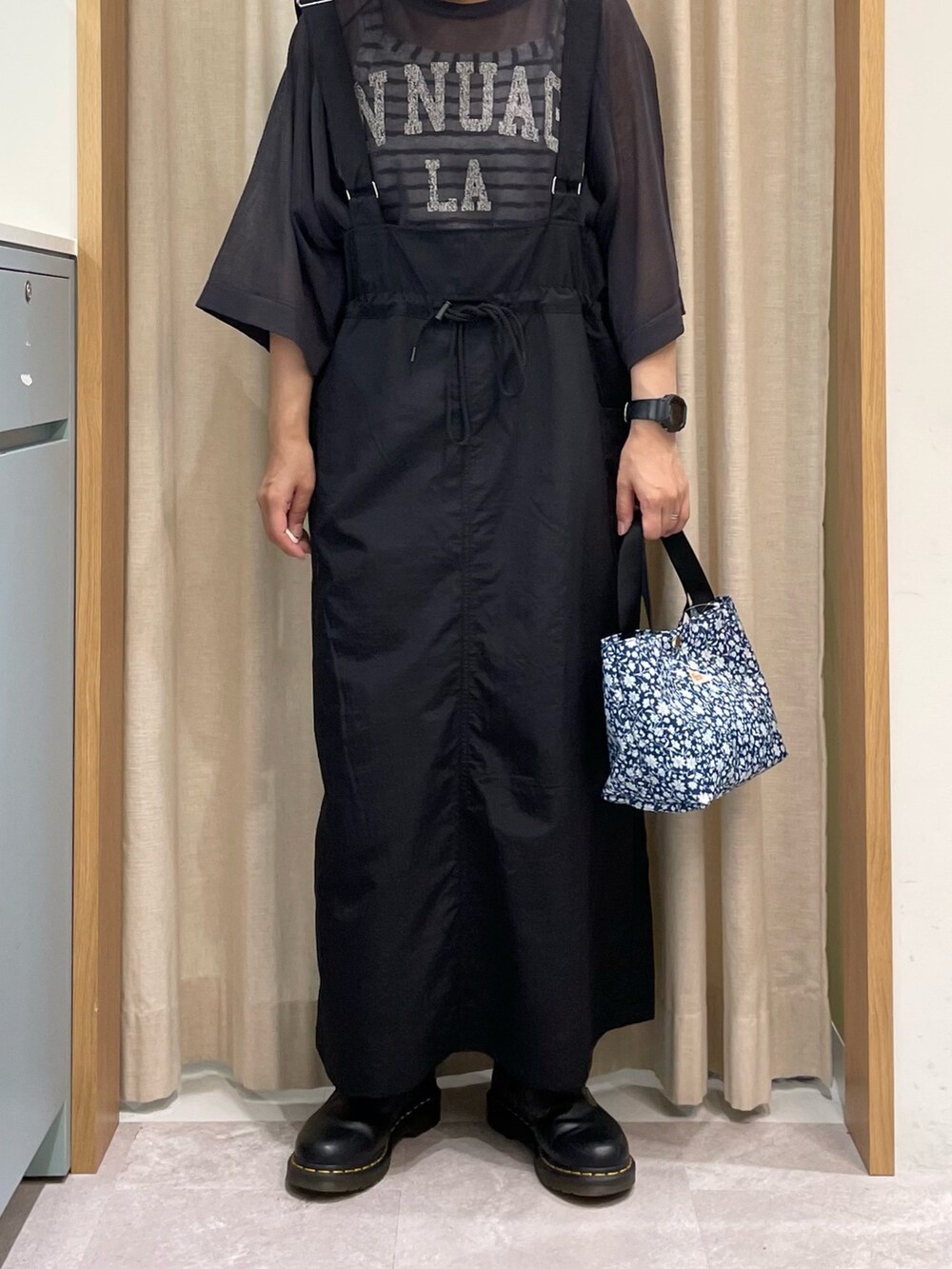 ホワイト系のTシャツ/カットソー、グレー系のニット/セーター、ブラック系のスカートを着用したレディースの春コーディネートの4枚目の写真