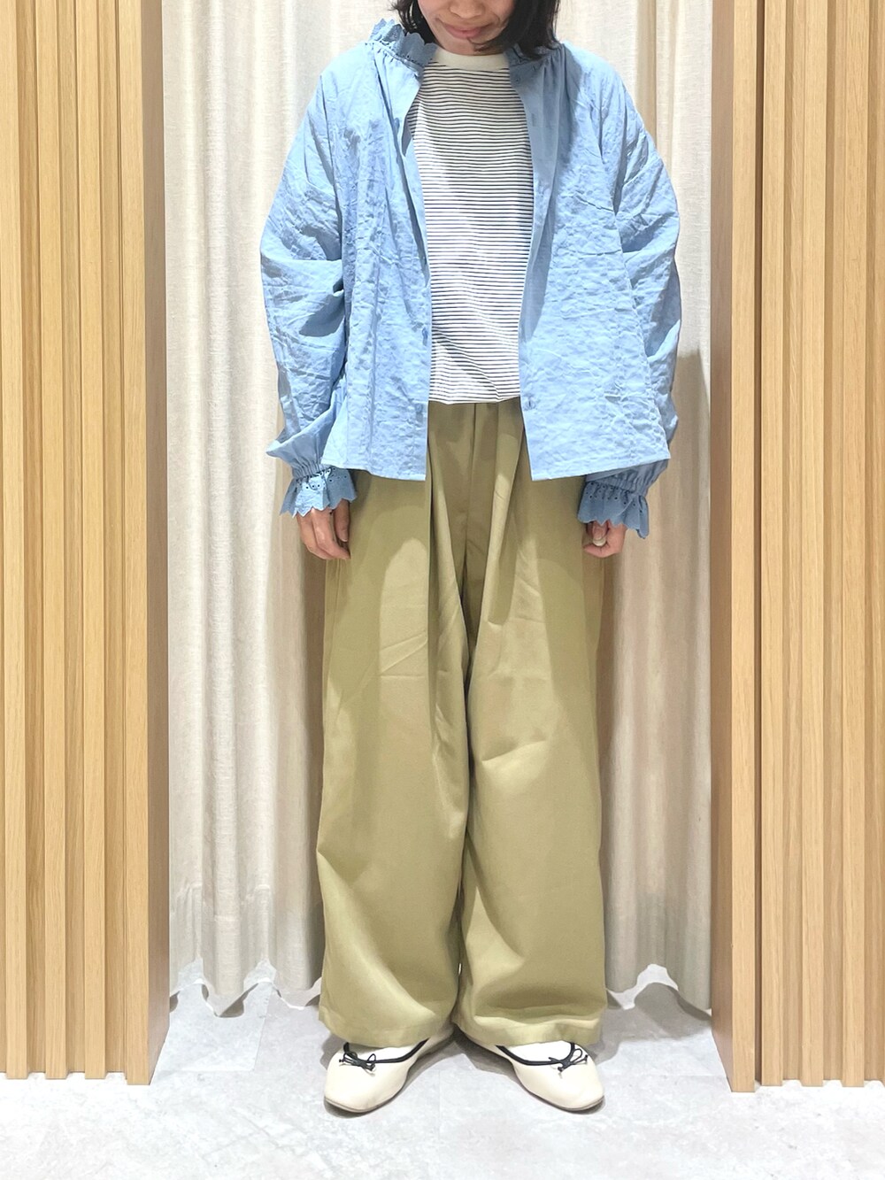 ブルー系のTシャツ/カットソー、ブルー系のシャツ/ブラウス、ベージュ系のスラックスを着用したレディースの冬コーディネートの2枚目の写真