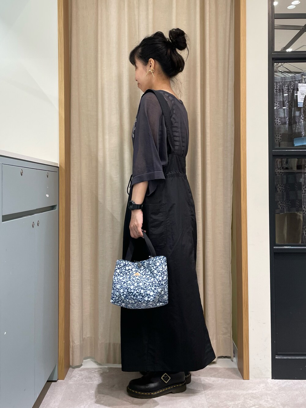 ホワイト系のTシャツ/カットソー、グレー系のニット/セーター、ブラック系のスカートを着用したレディースの春コーディネートの3枚目の写真