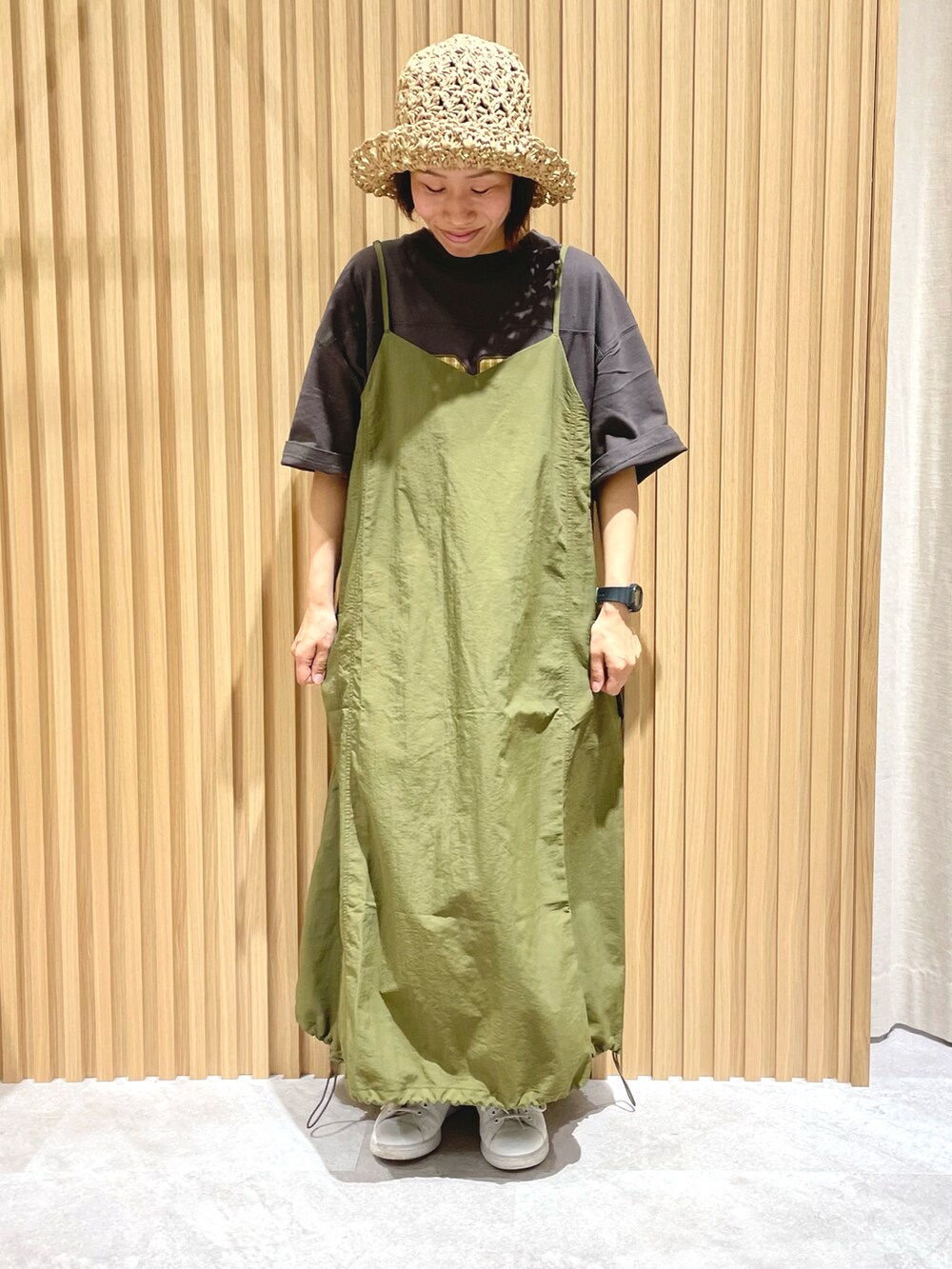 グリーン系のワンピース、グレー系のTシャツ/カットソー、ホワイト系のスニーカーを着用したレディースの夏コーディネートの2枚目の写真