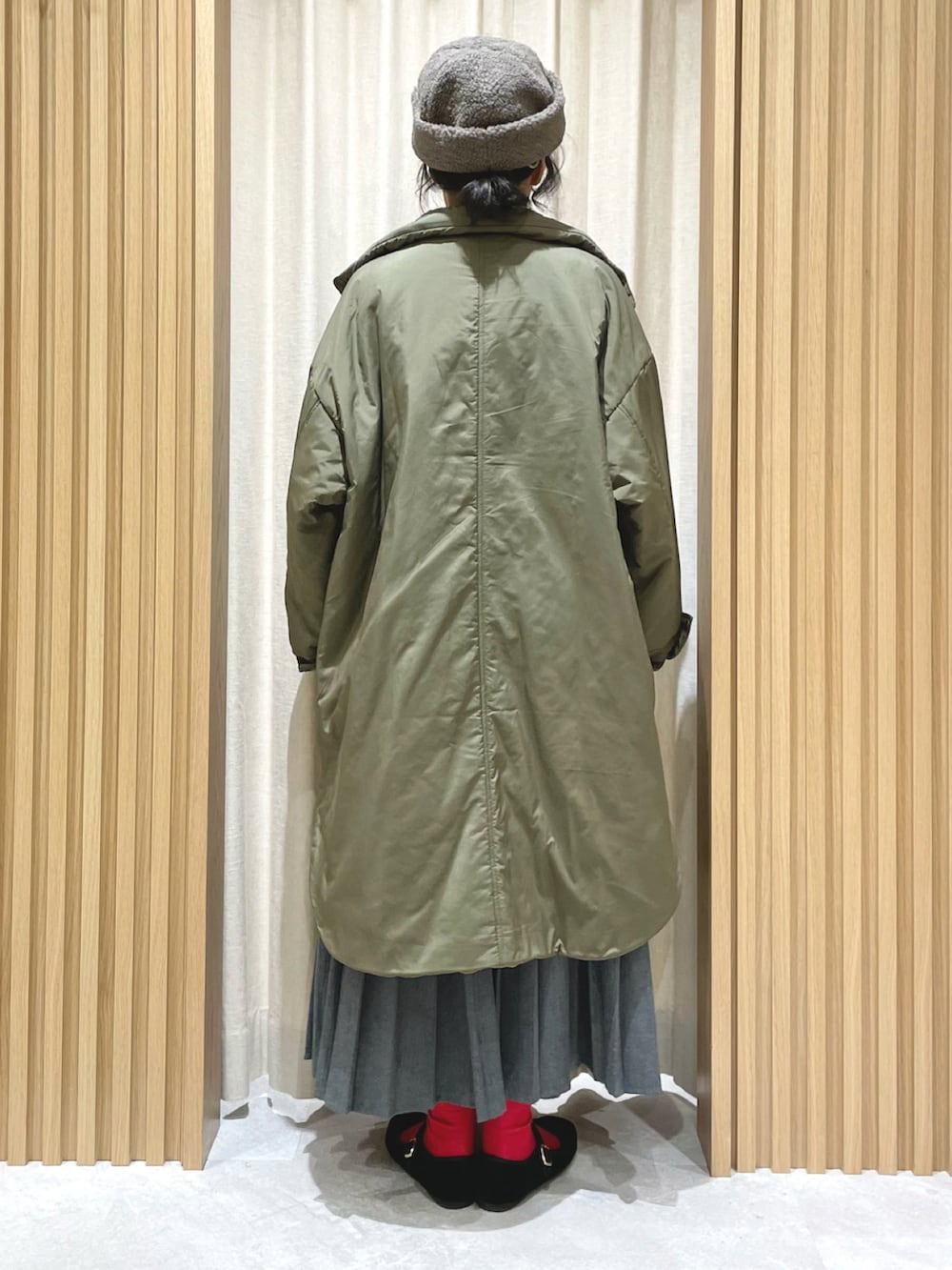 ブルー系のニット/セーター、グレー系のスカート、グリーン系のその他アウターを着用したレディースの冬コーディネートの4枚目の写真