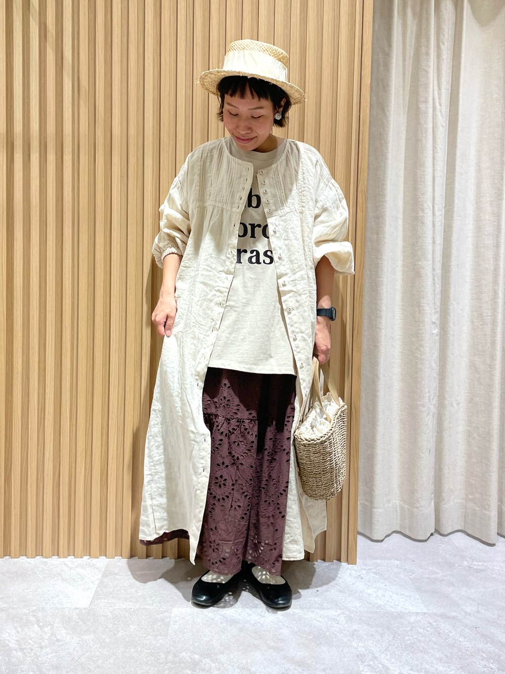 ベージュ系のTシャツ/カットソー、ホワイト系のワンピース、ベージュ系のハンドバッグを着用したレディースの春コーディネートの2枚目の写真