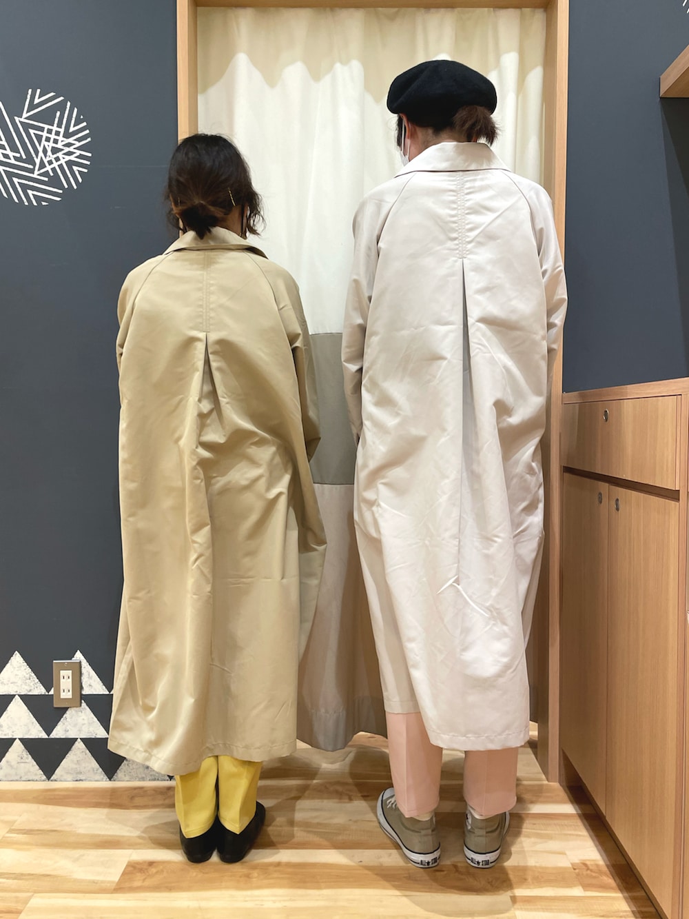 ベージュ系のステンカラーコート、グレー系のステンカラーコート、グリーン系のニット/セーターを着用したレディースの冬コーディネートの2枚目の写真