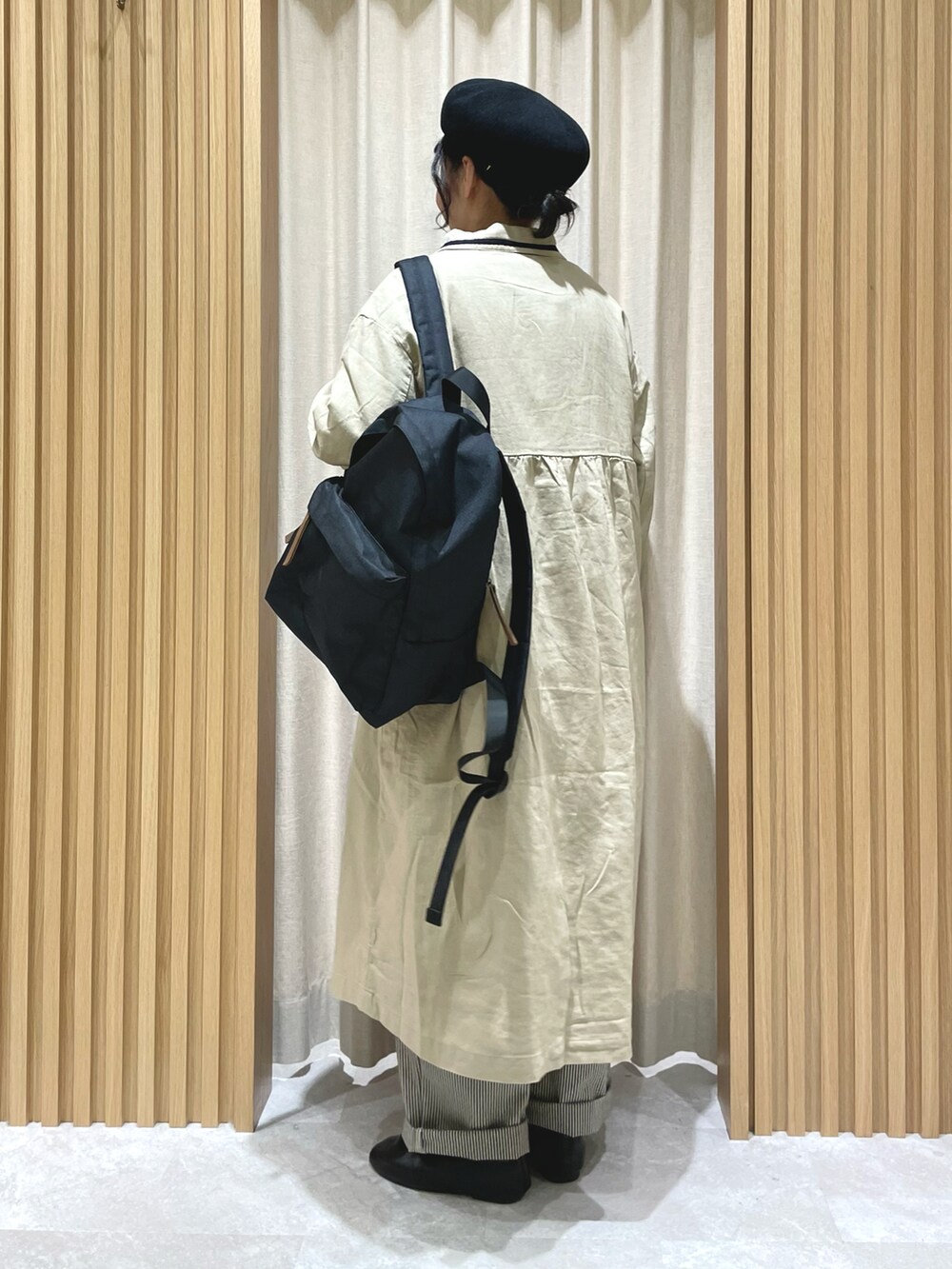 ホワイト系のチュニック、ホワイト系のベスト、ベージュ系のその他アウターを着用したレディースの春コーディネートの2枚目の写真