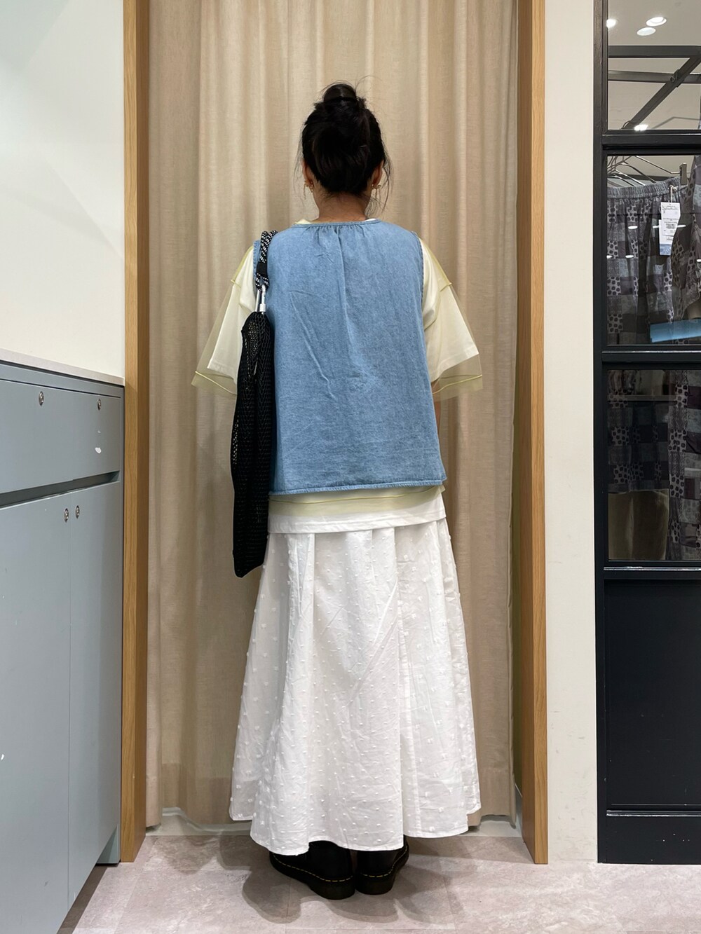 グリーン系のTシャツ/カットソー、ブルー系のベスト、ブラック系のハンドバッグを着用したレディースの春コーディネートの4枚目の写真