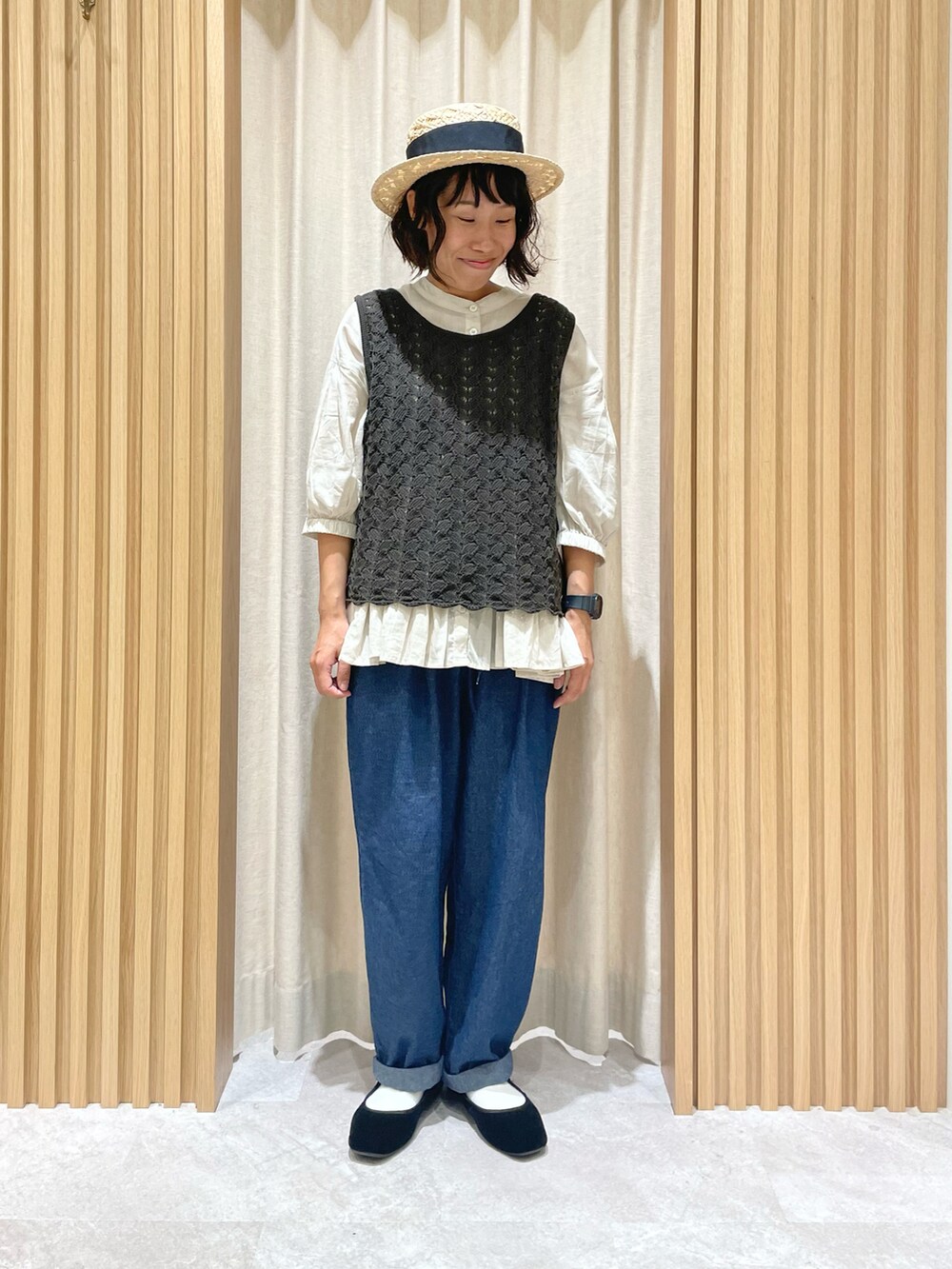 グレー系のベスト、ベージュ系のシャツ/ブラウス、ブルー系のデニムパンツを着用したレディースの夏コーディネートの4枚目の写真