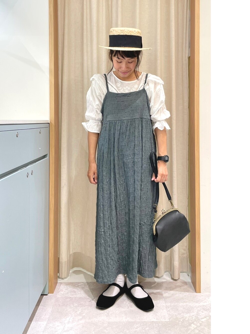 ホワイト系のシャツ/ブラウス、ブルー系のワンピース、ブラック系のハンドバッグを着用したレディースの夏コーディネートの2枚目の写真