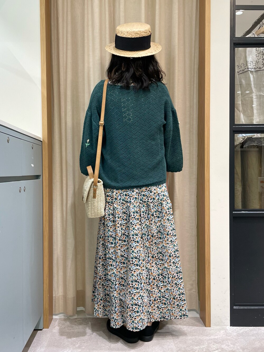 ホワイト系のワンピース、グリーン系のカーディガン/ボレロ、ホワイト系のハンドバッグを着用したレディースの夏コーディネートの3枚目の写真