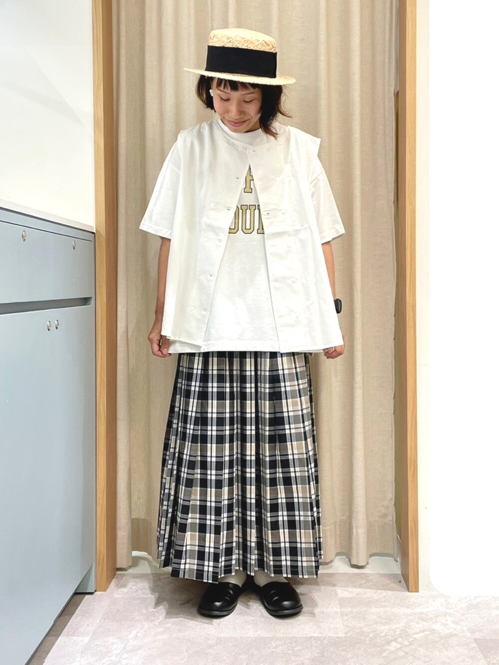 ホワイト系のTシャツ/カットソー、ホワイト系のベスト、ベージュ系のスカートを着用したレディースの夏コーディネートの3枚目の写真