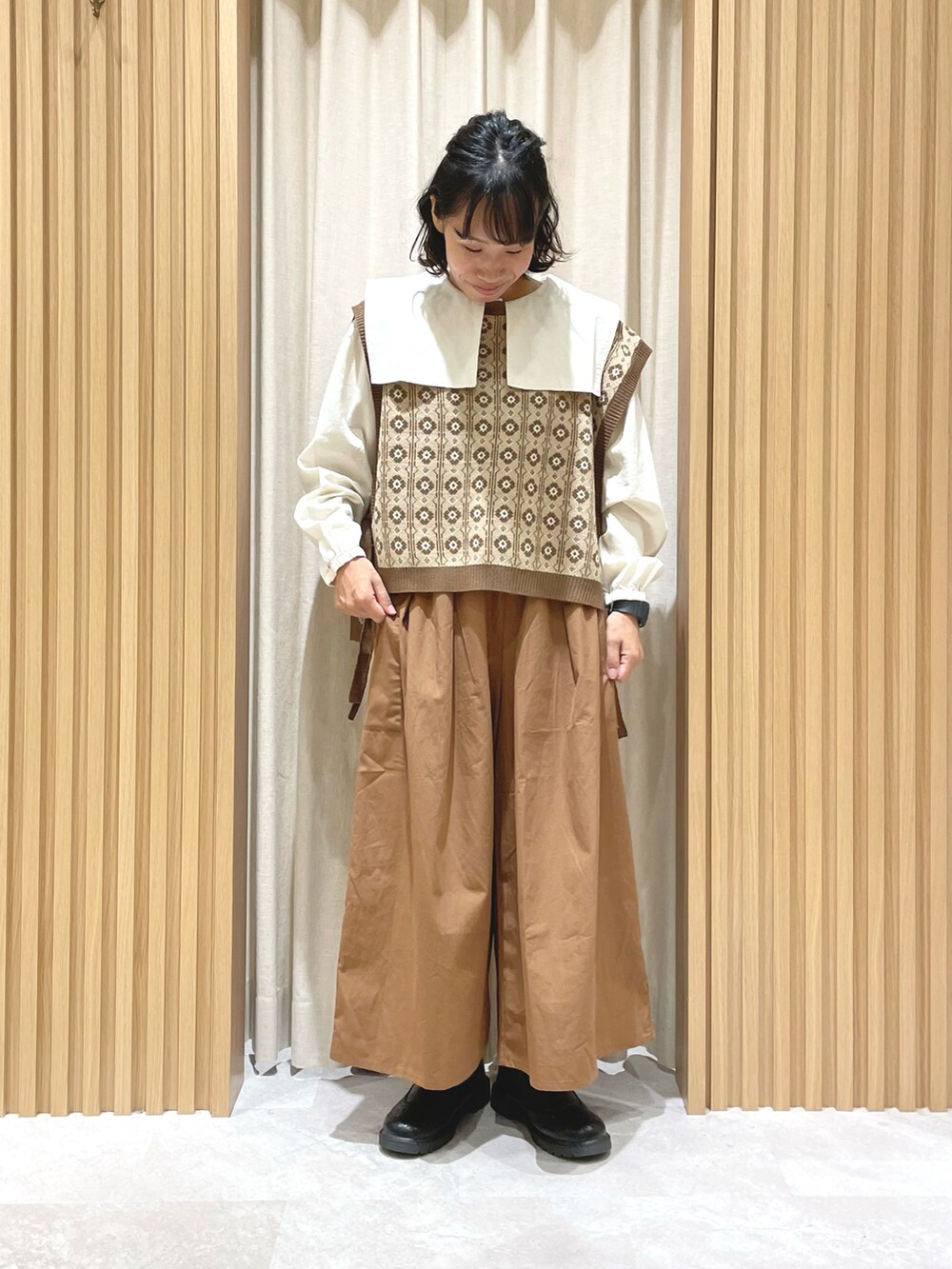 ホワイト系のシャツ/ブラウス、ベージュ系のブルゾン、ブラウン系のベストを着用したレディースの秋コーディネートの3枚目の写真