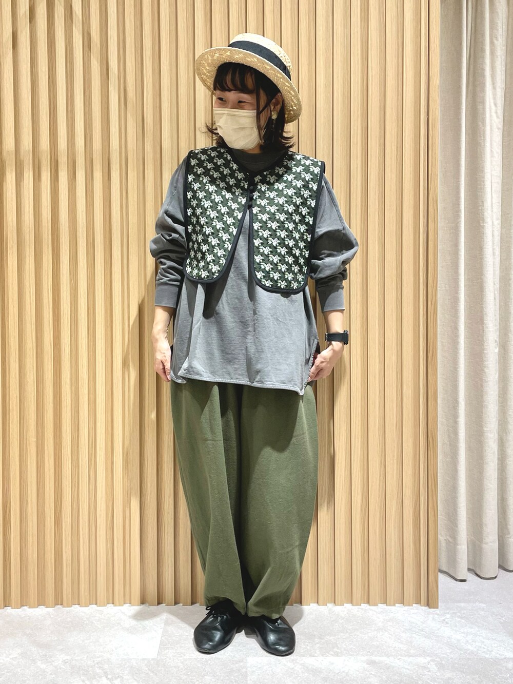 グレー系のベスト、グレー系のTシャツ/カットソー、グリーン系のその他パンツを着用したレディースの春コーディネートの2枚目の写真