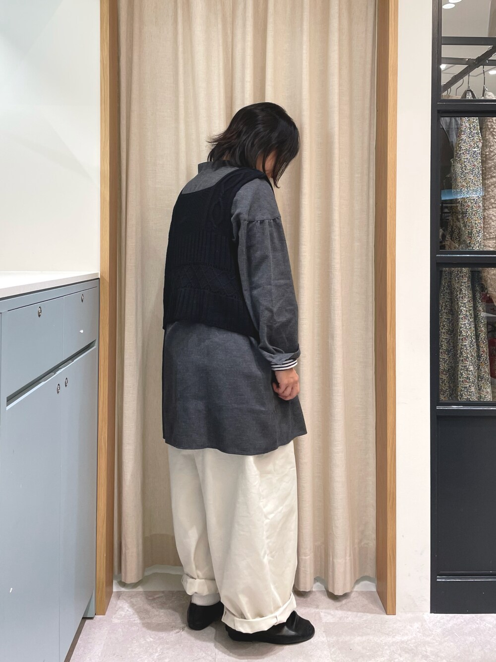 グレー系のチュニック、ブラック系のベスト、ブルー系のTシャツ/カットソーを着用したレディースの冬コーディネートの2枚目の写真