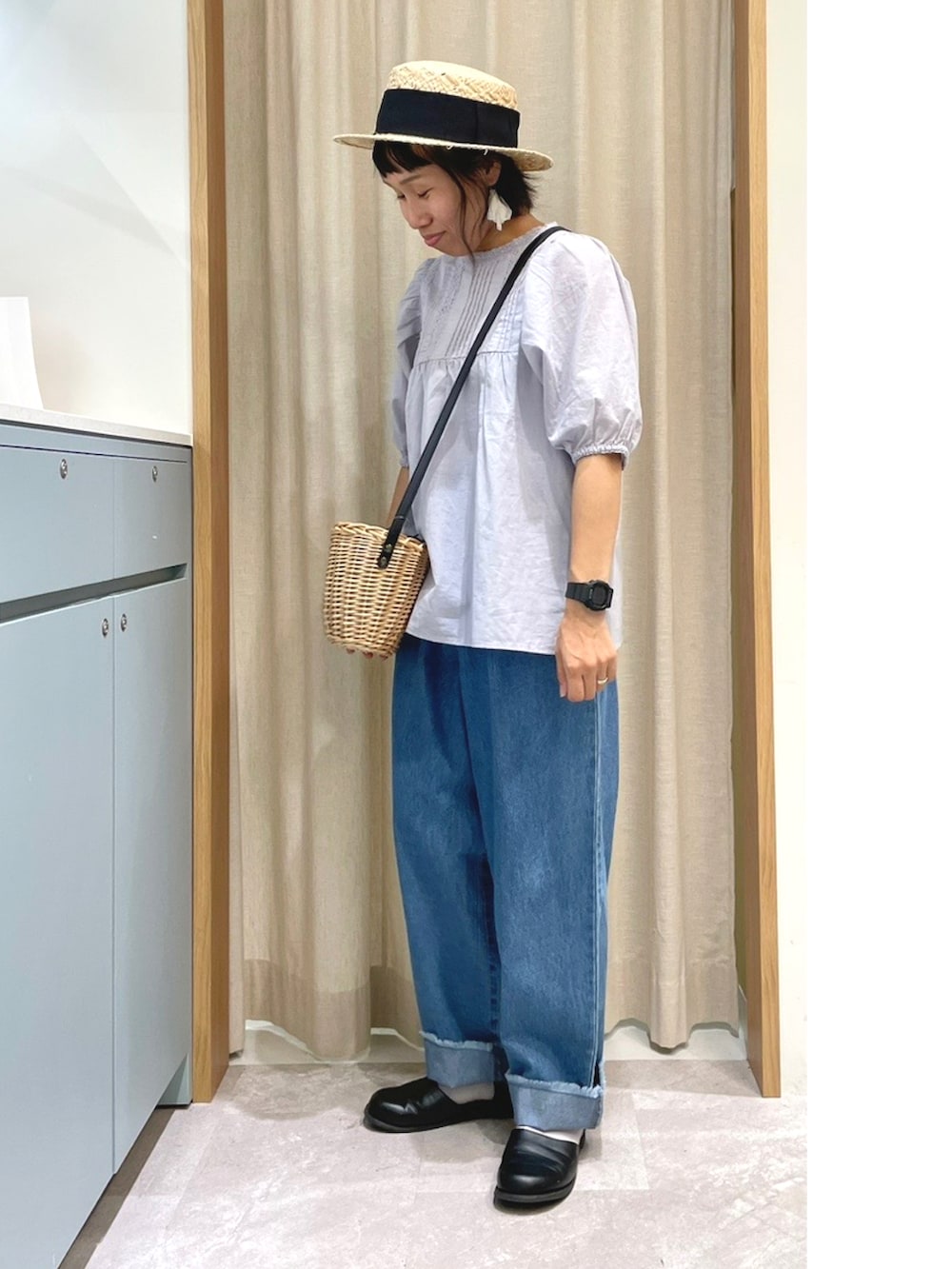 ブルー系のシャツ/ブラウス、ブラック系のハンドバッグ、ブルー系のデニムパンツを着用したレディースの夏コーディネートの3枚目の写真