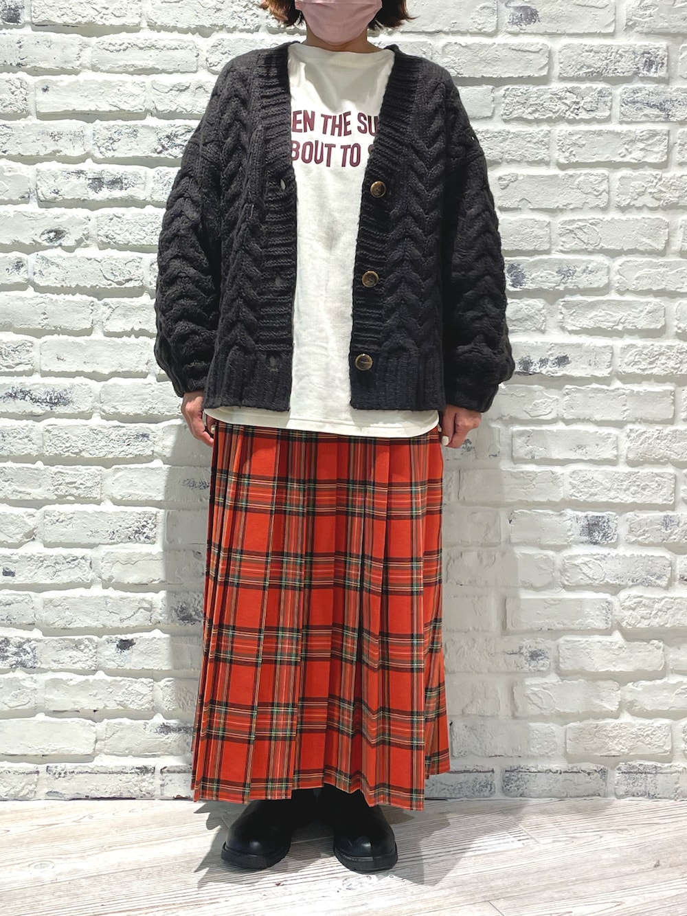 ホワイト系のTシャツ/カットソー、グレー系のカーディガン/ボレロ、ブラック系のブーツを着用したレディースの冬コーディネートの3枚目の写真