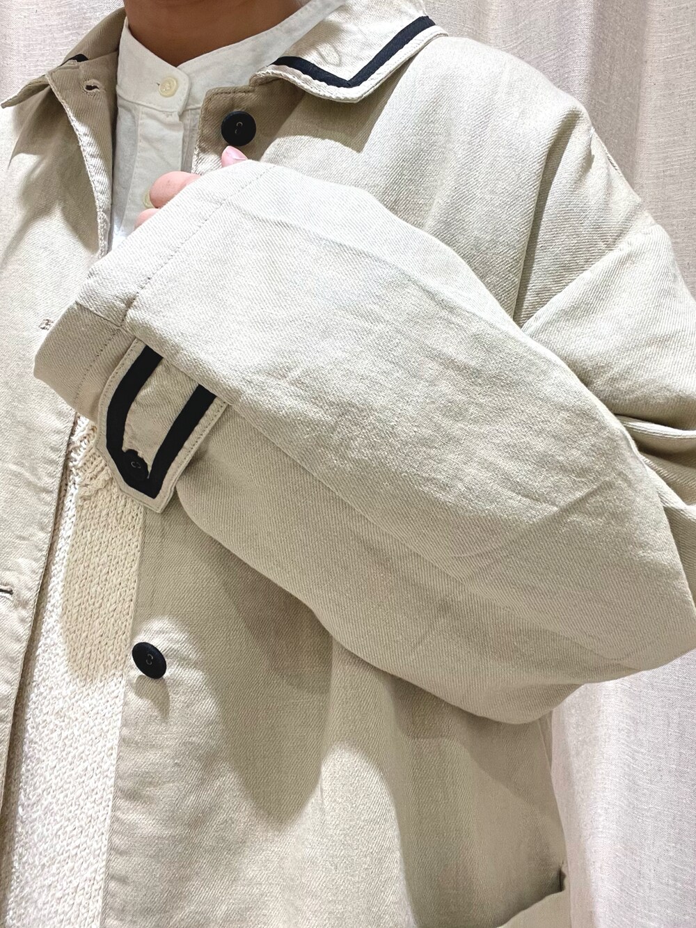 ホワイト系のチュニック、ホワイト系のベスト、ベージュ系のその他アウターを着用したレディースの春コーディネートの4枚目の写真