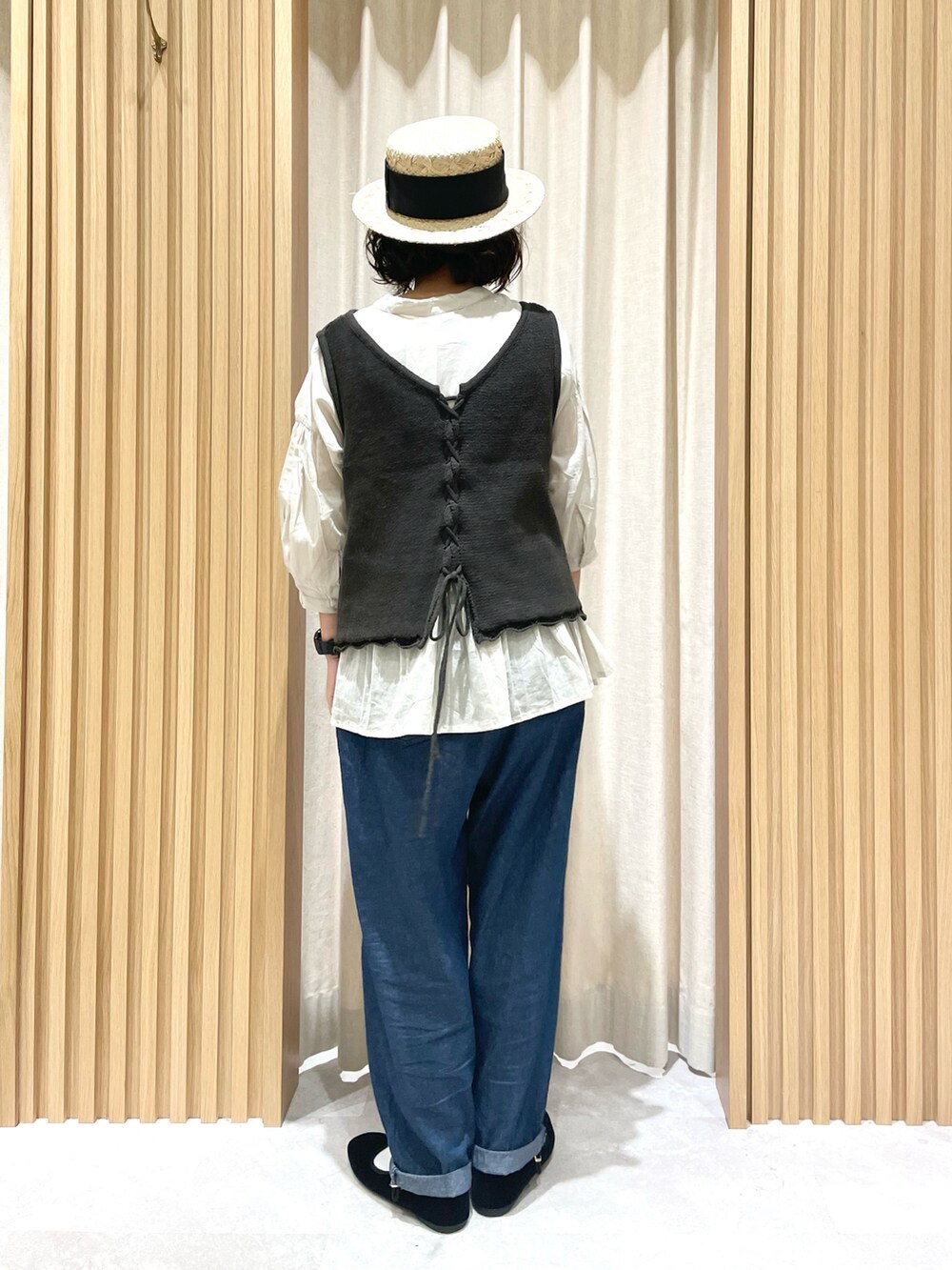 グレー系のベスト、ベージュ系のシャツ/ブラウス、ブルー系のデニムパンツを着用したレディースの夏コーディネートの2枚目の写真