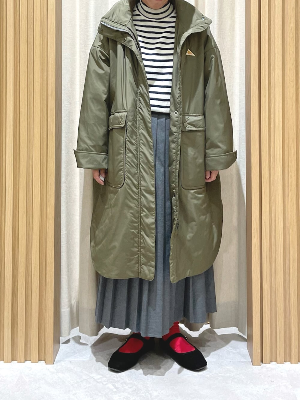 ブルー系のニット/セーター、グレー系のスカート、グリーン系のその他アウターを着用したレディースの冬コーディネートの2枚目の写真