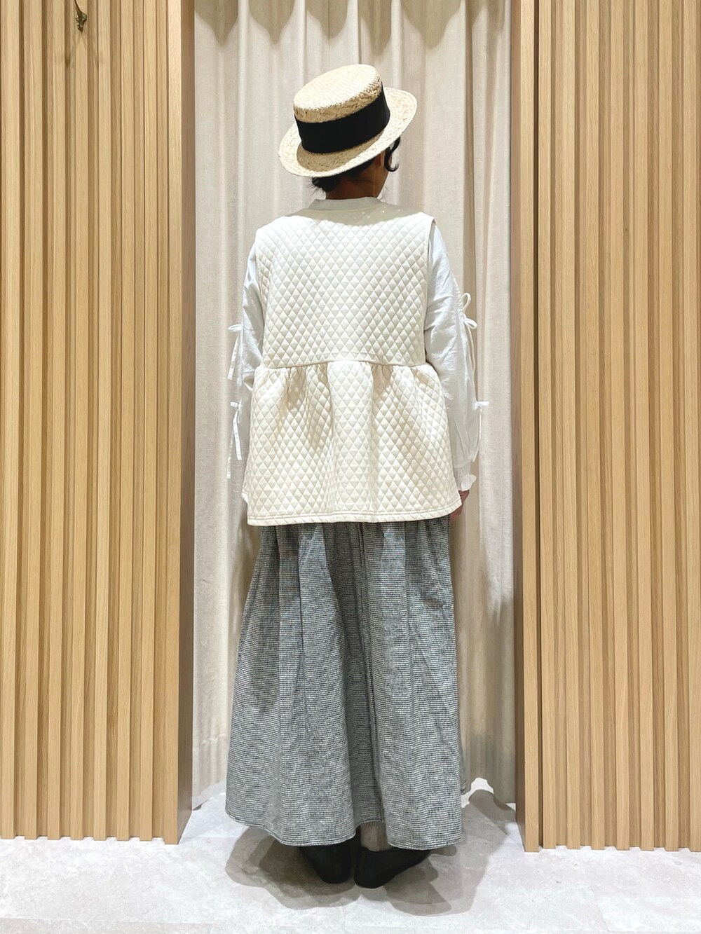 ホワイト系のシャツ/ブラウス、ホワイト系のベスト、グレー系のスカートを着用したレディースの冬コーディネートの3枚目の写真