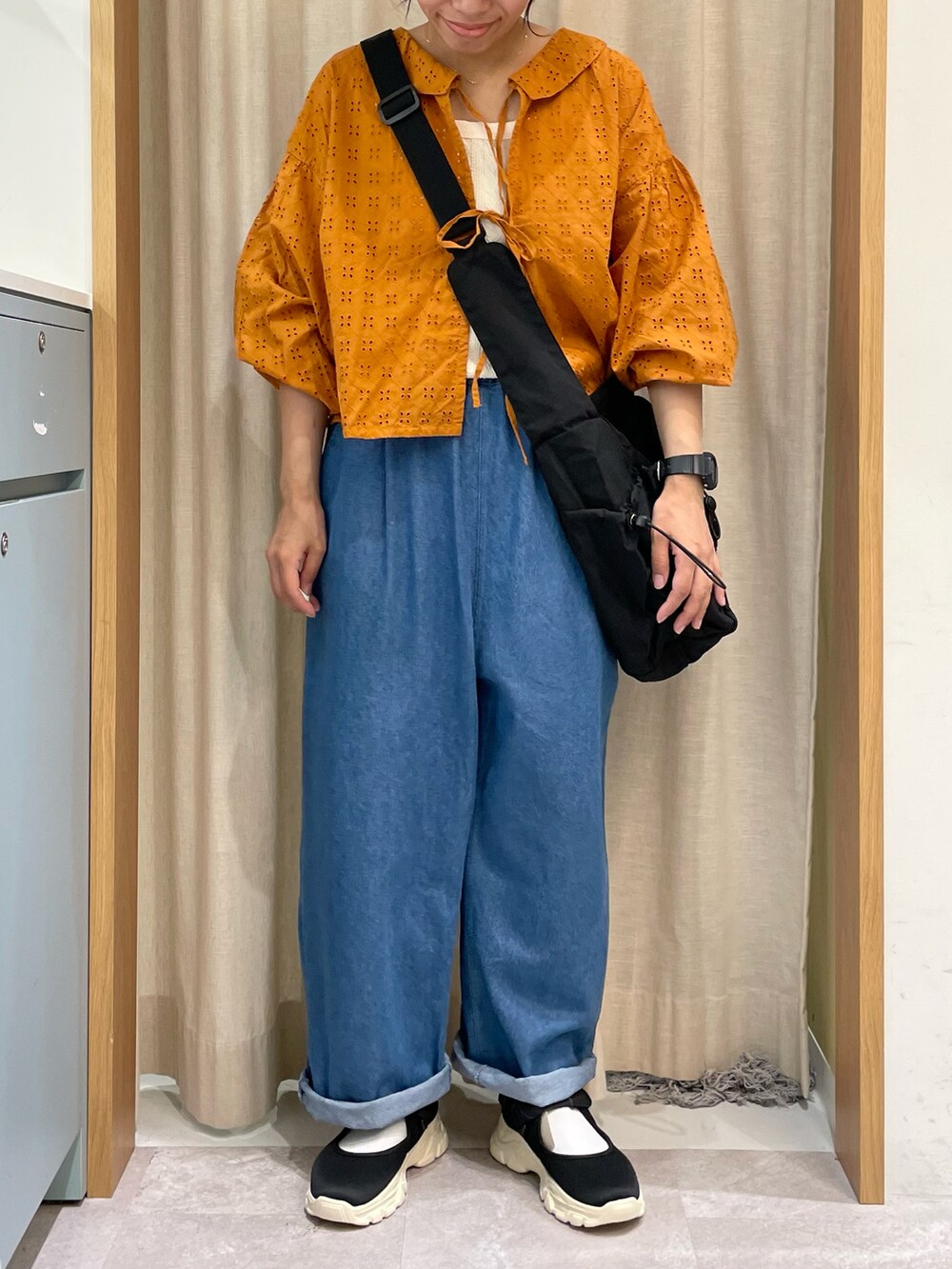 オレンジ系のシャツ/ブラウス、ホワイト系のTシャツ/カットソー、ブラック系のハンドバッグを着用したレディースの夏コーディネートの3枚目の写真