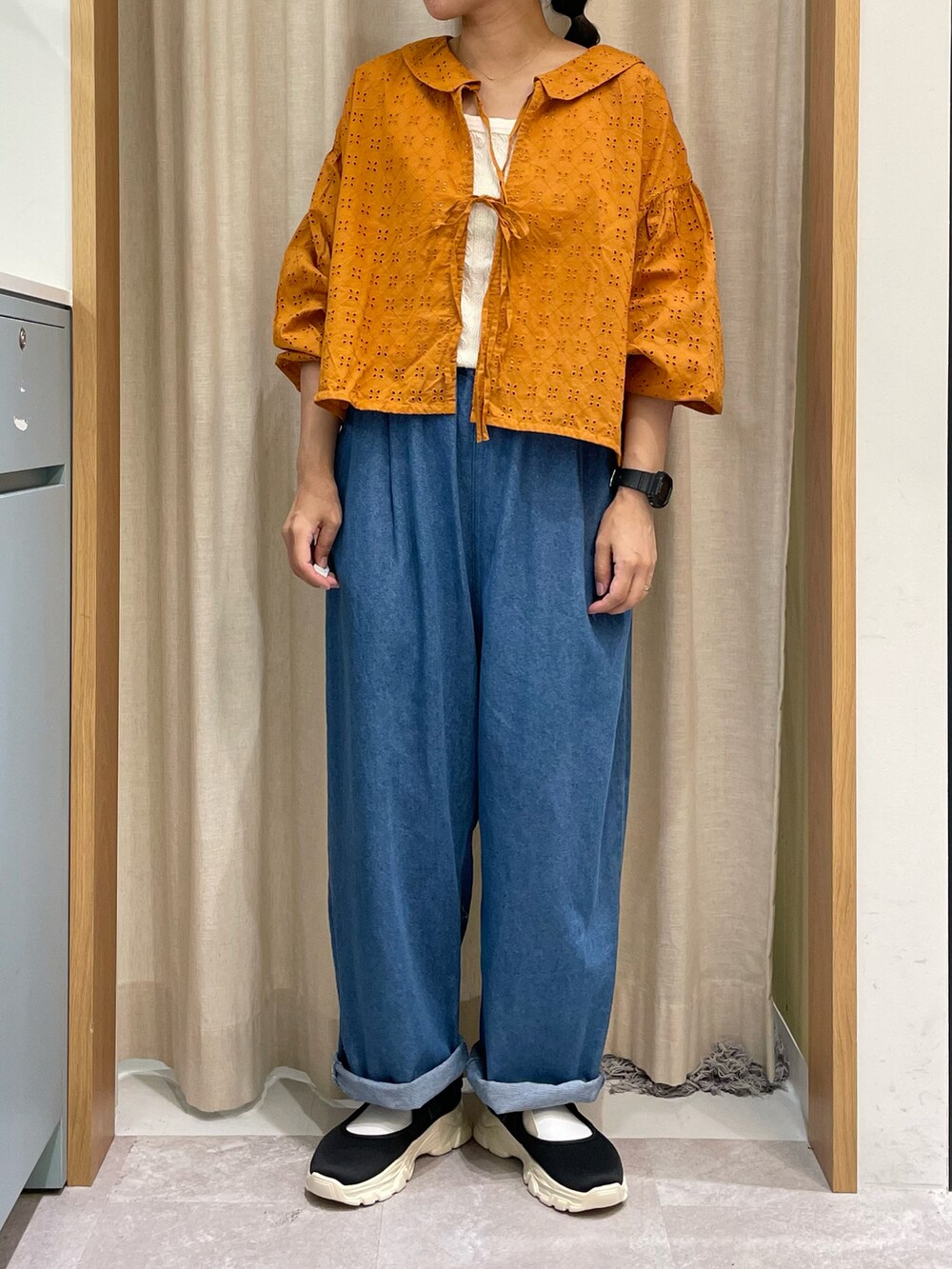 オレンジ系のシャツ/ブラウス、ホワイト系のTシャツ/カットソー、ブラック系のハンドバッグを着用したレディースの夏コーディネートの4枚目の写真