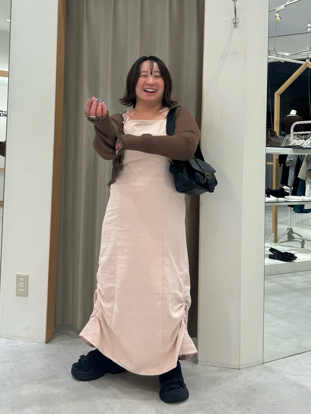 ピンク系のワンピース、ブラウン系のカーディガン/ボレロ、ブラック系のショルダーバッグを着用したレディースの夏コーディネートの2枚目の写真