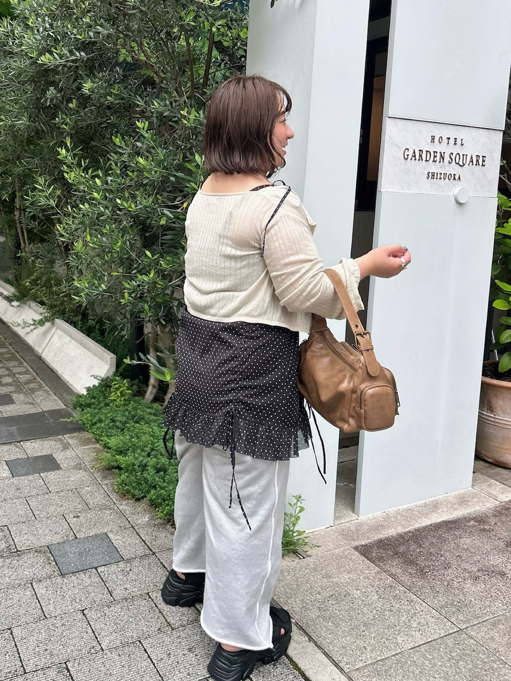 ブラック系のシャツ/ブラウス、ブラウン系のショルダーバッグ、ホワイト系のカーディガン/ボレロを着用したレディースの夏コーディネートの4枚目の写真