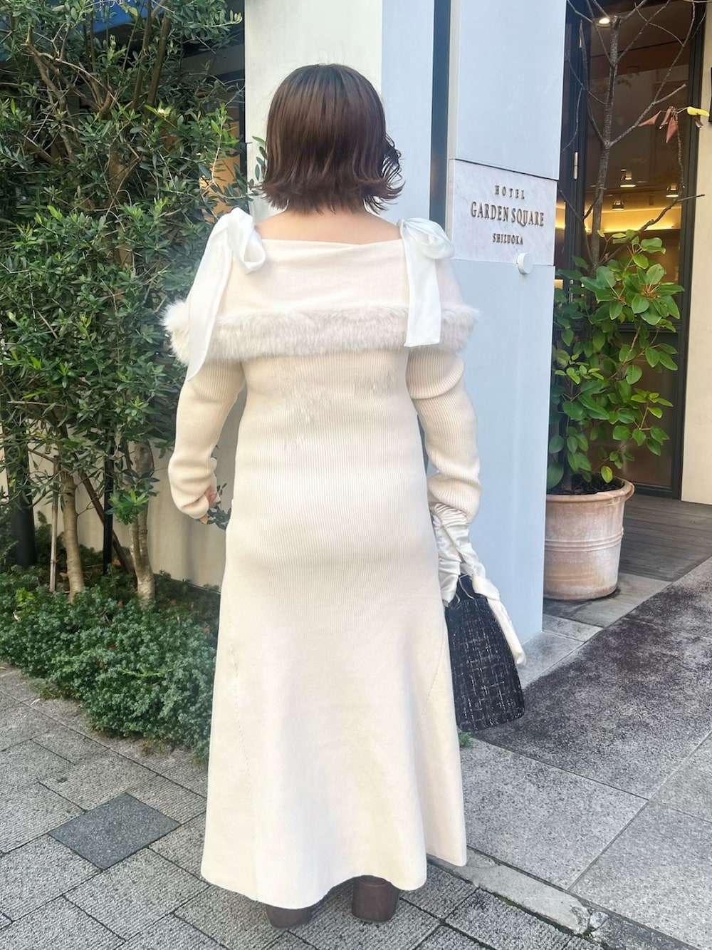ホワイト系のワンピース、ブラウン系のブーツ、ブラック系のトートバッグを着用したレディースの秋コーディネートの4枚目の写真