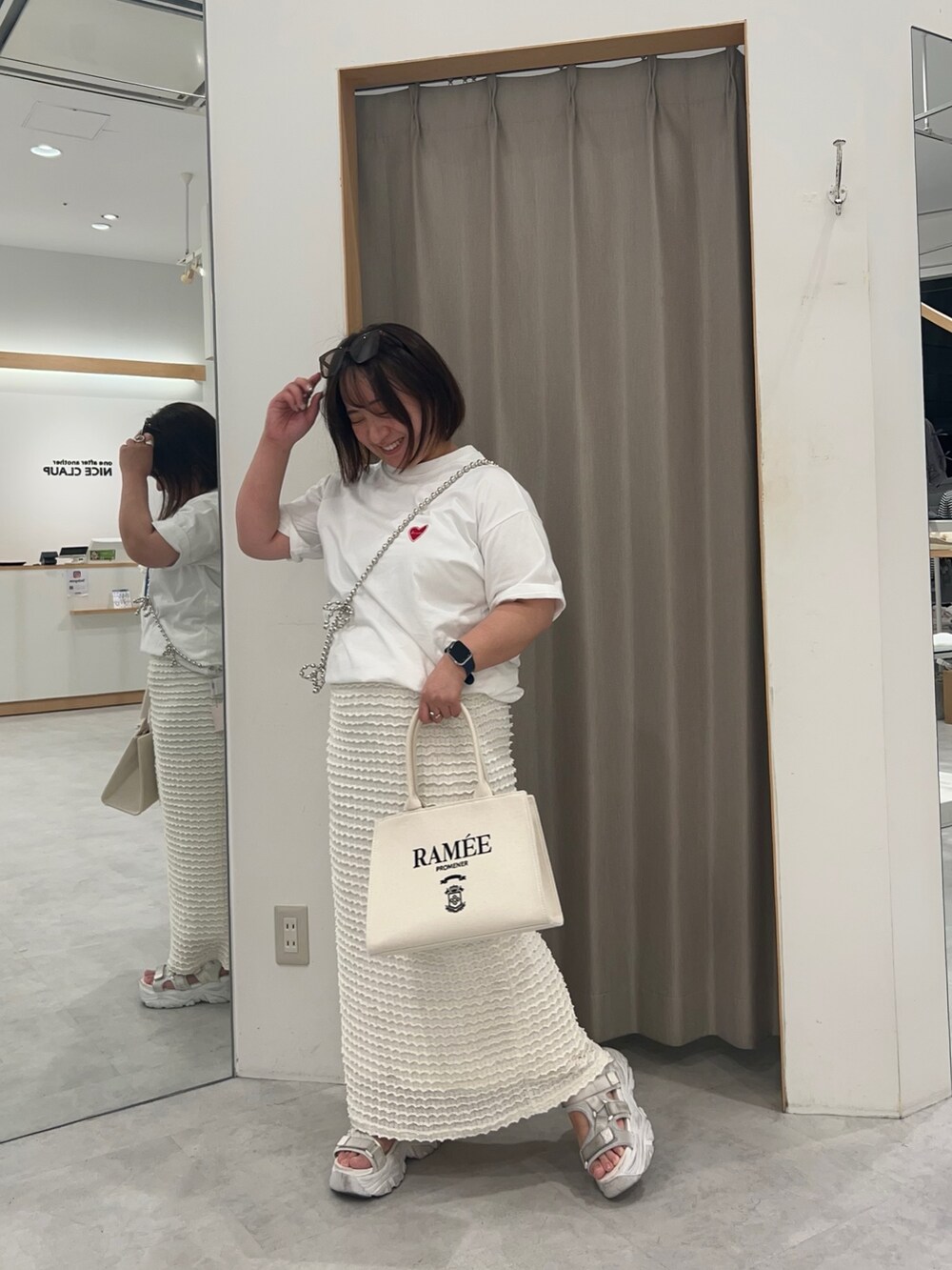 ホワイト系のTシャツ/カットソー、ホワイト系のトートバッグ、ホワイト系のスカートを着用したレディースの春コーディネートの2枚目の写真