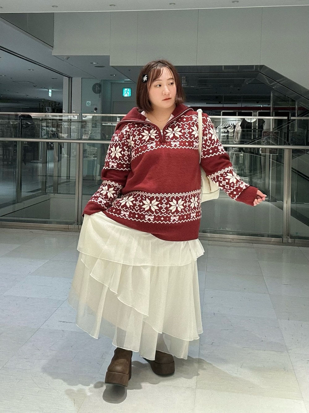 ホワイト系のスカート、ブラウン系のブーツ、レッド系のニット/セーターを着用したレディースの冬コーディネートの7枚目の写真