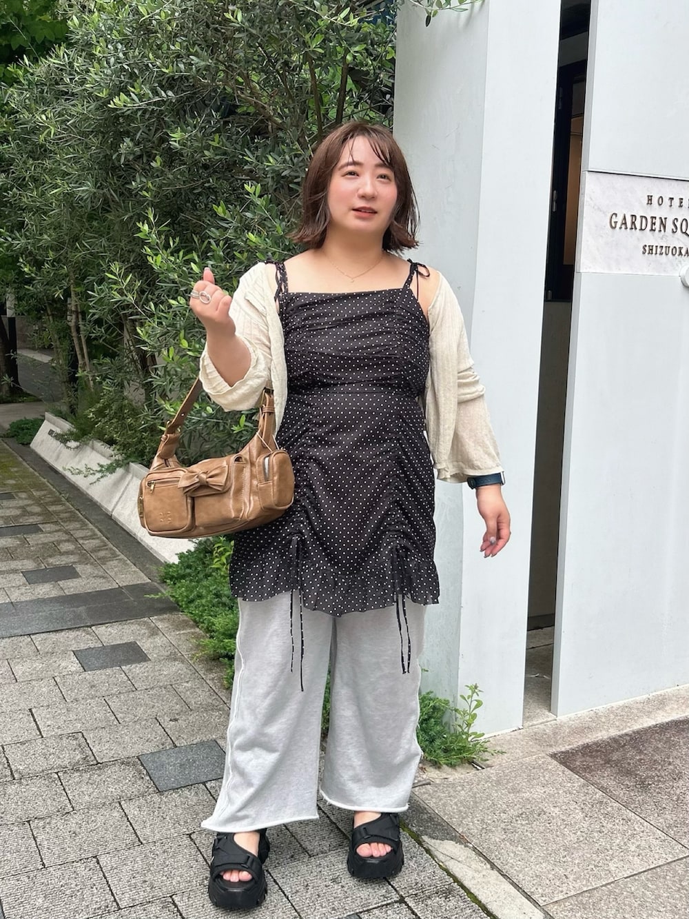 ブラック系のシャツ/ブラウス、ブラウン系のショルダーバッグ、ホワイト系のカーディガン/ボレロを着用したレディースの夏コーディネートの2枚目の写真