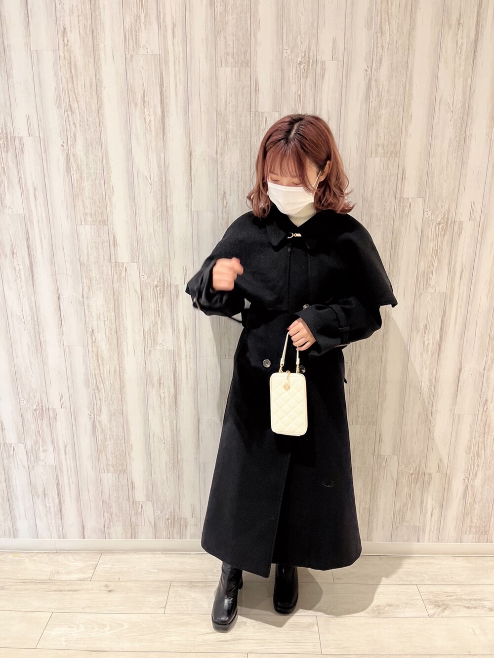 ホワイト系のニット/セーター、ホワイト系のその他パンツ、ブラック系のブーツを着用したレディースの秋コーディネートの2枚目の写真