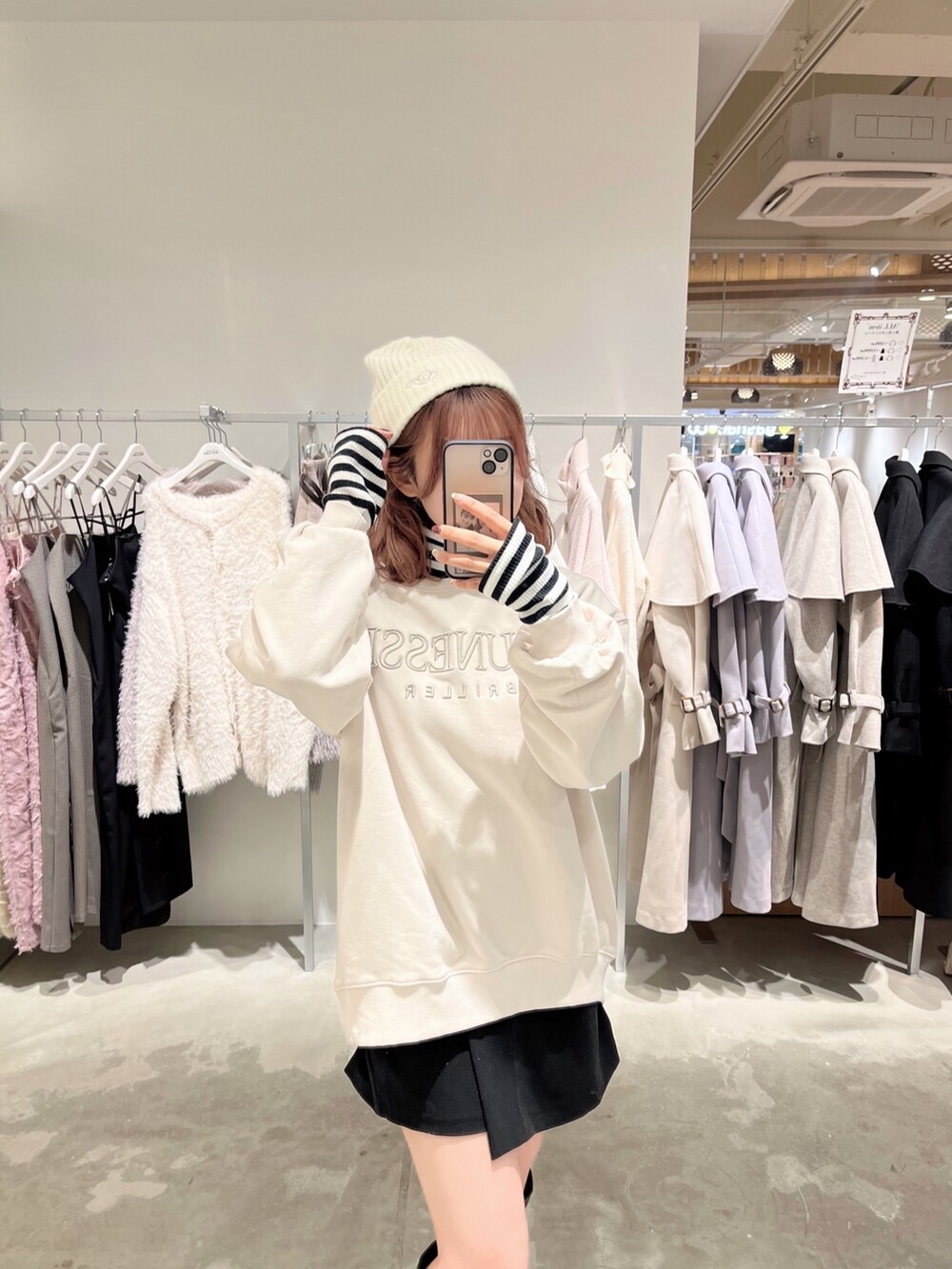 ホワイト系のノーカラーコート、ブラック系のTシャツ/カットソー、ブラック系のその他パンツを着用したレディースの冬コーディネートの2枚目の写真