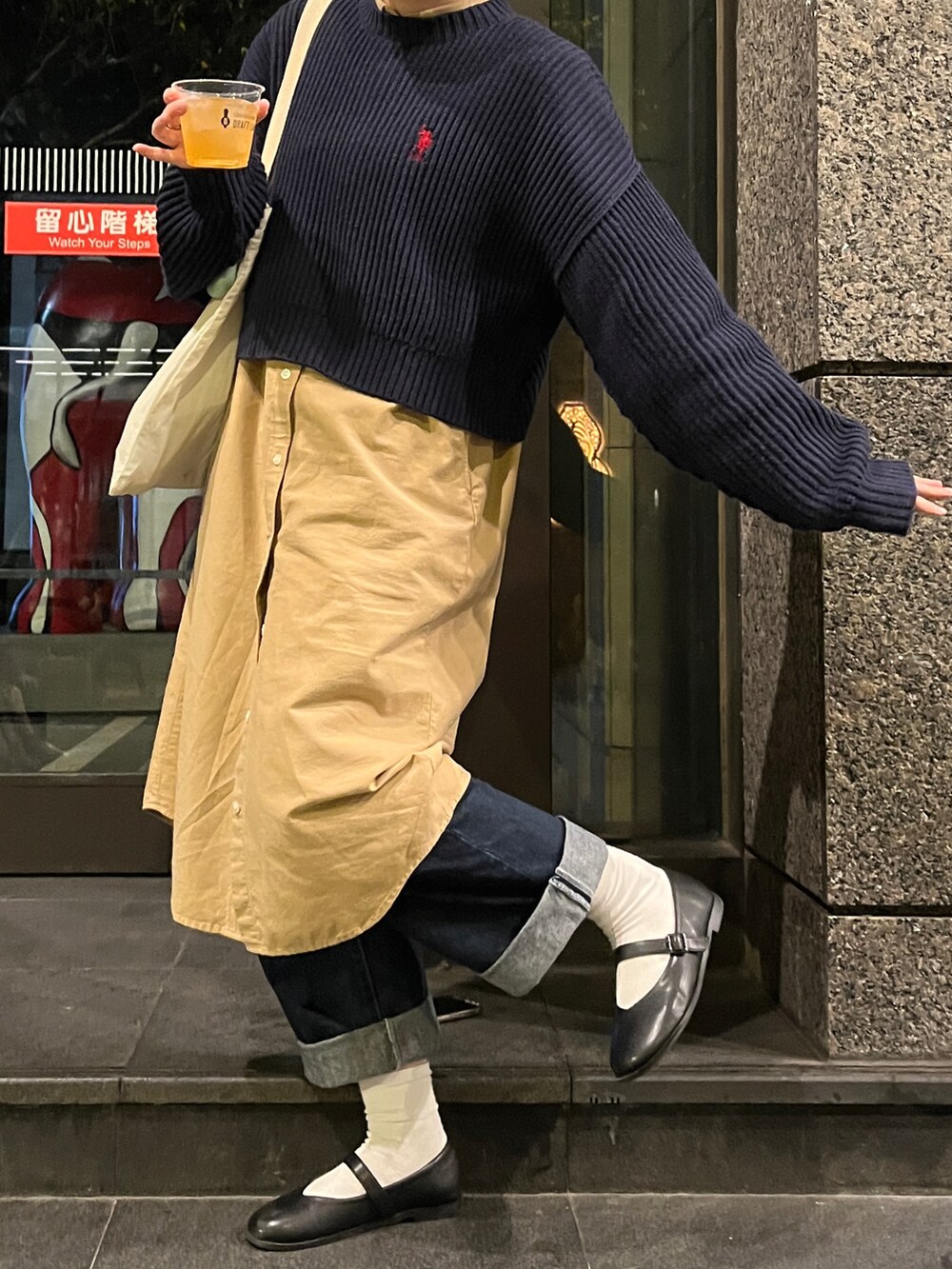 ブルー系のニット/セーター、ブルー系のデニムパンツ、ベージュ系のシャツ/ブラウスを着用したレディースの冬コーディネートの2枚目の写真